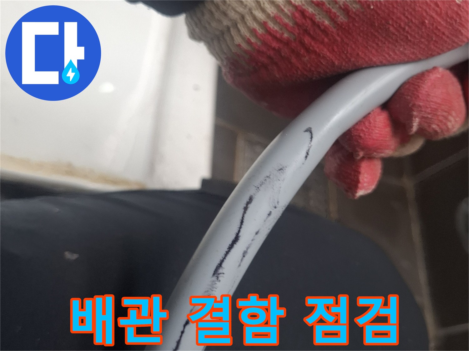 장갑을 낀 손으로 배관의 곡선을 잡고 있는 모습