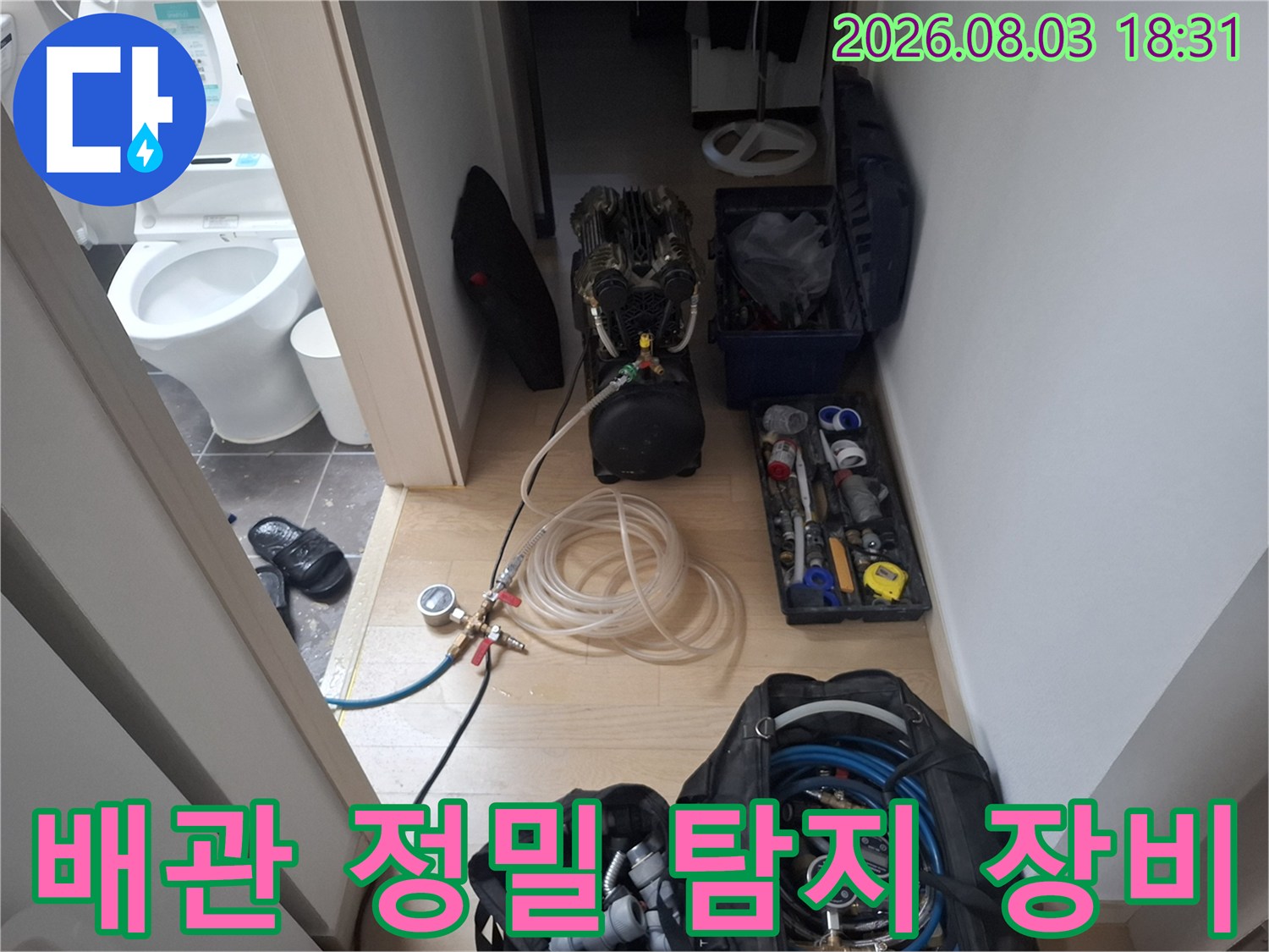 화장실 안쪽에서 고성능 청음 및 가스 탐지기를 사용하여 배관 누수 지점을 찾는 모습