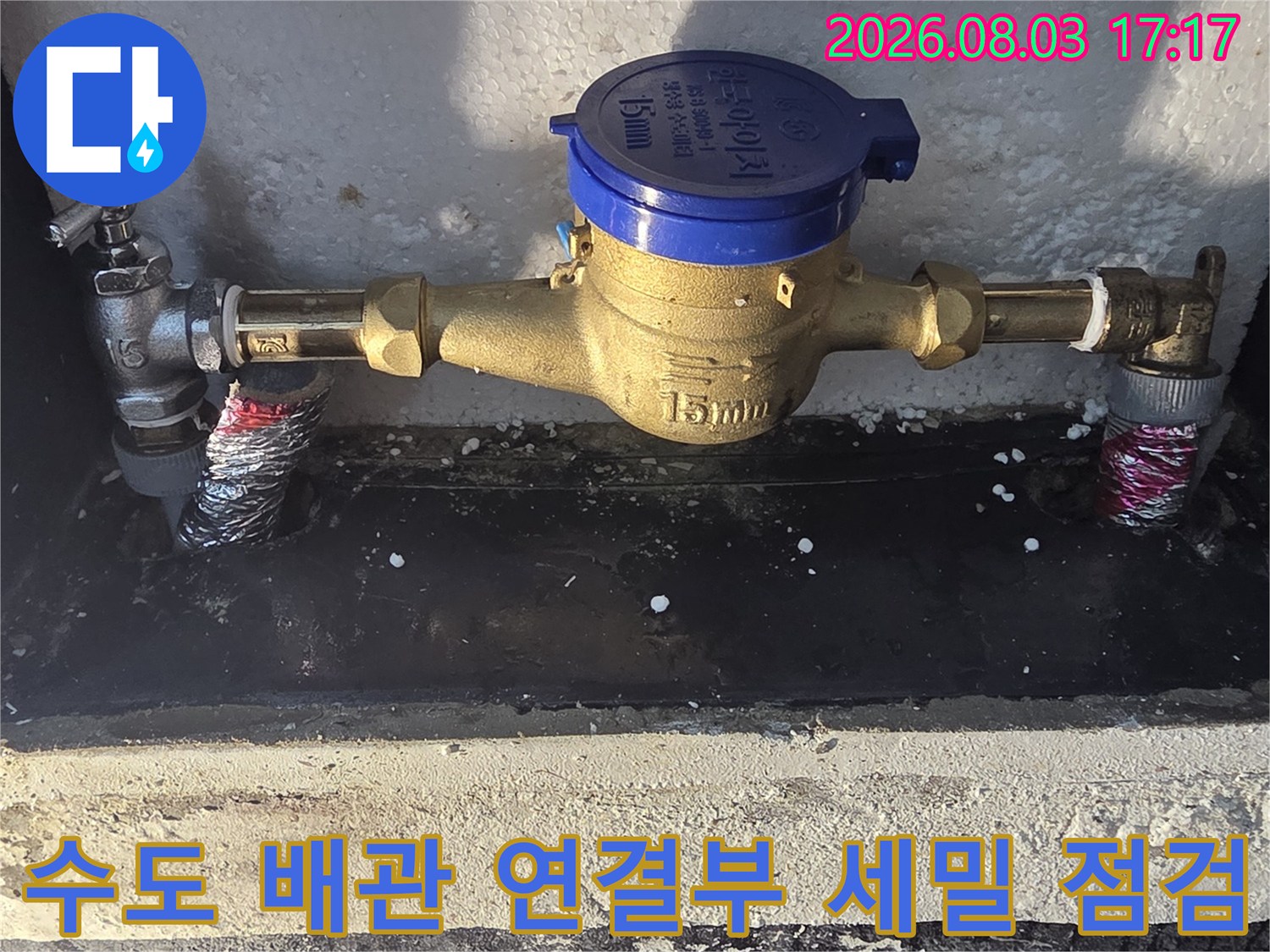 계량기함 내부에 설치된 수도 계량기와 금속 배관 체결 부위