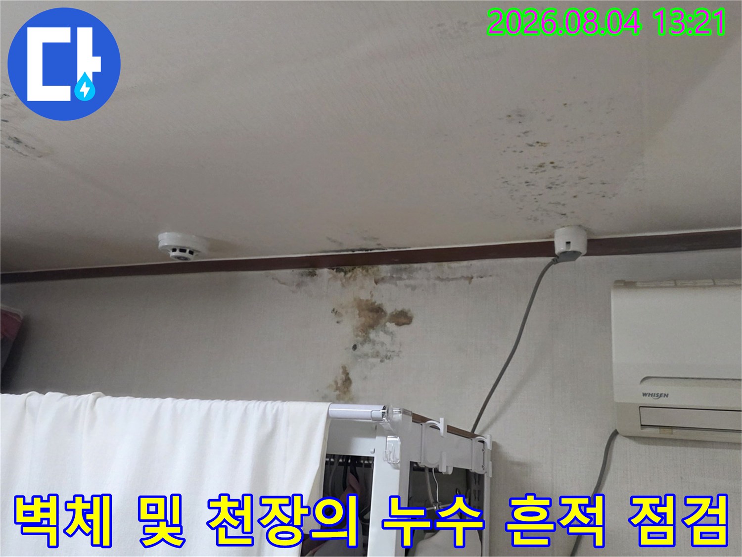 천장 마감재와 벽면이 만나는 구간에 발생한 누수 얼룩을 촬영한 사진