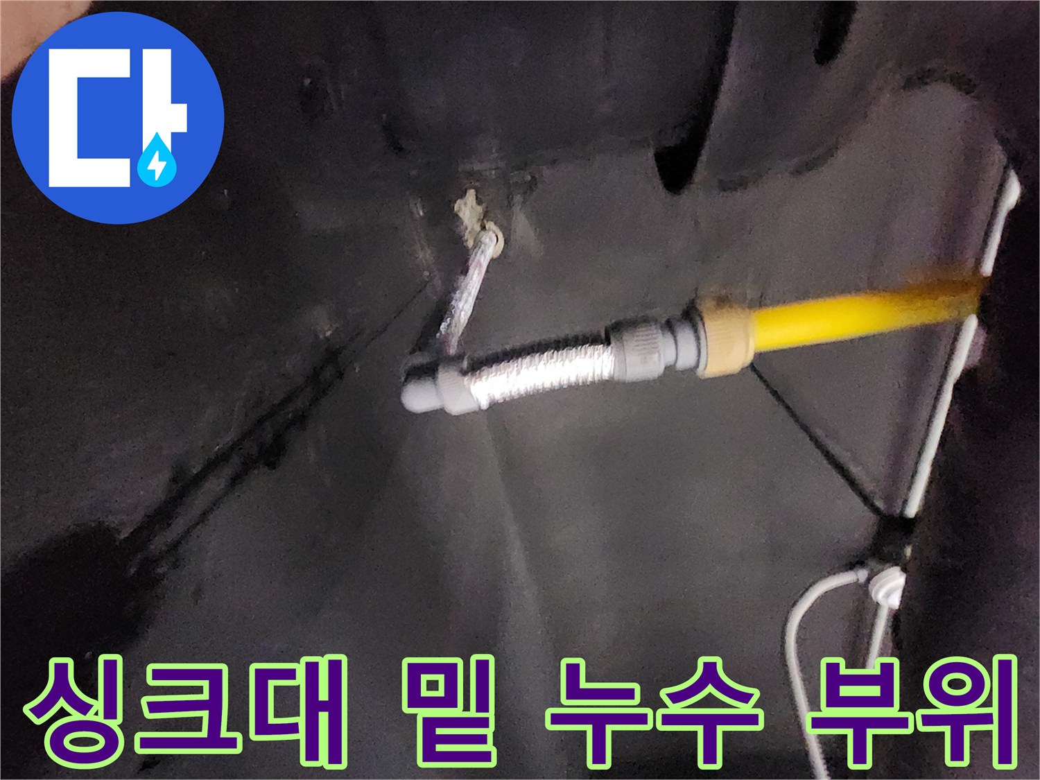 물기가 스며든 벽면과 연결된 노란색 및 은색 배관 사진