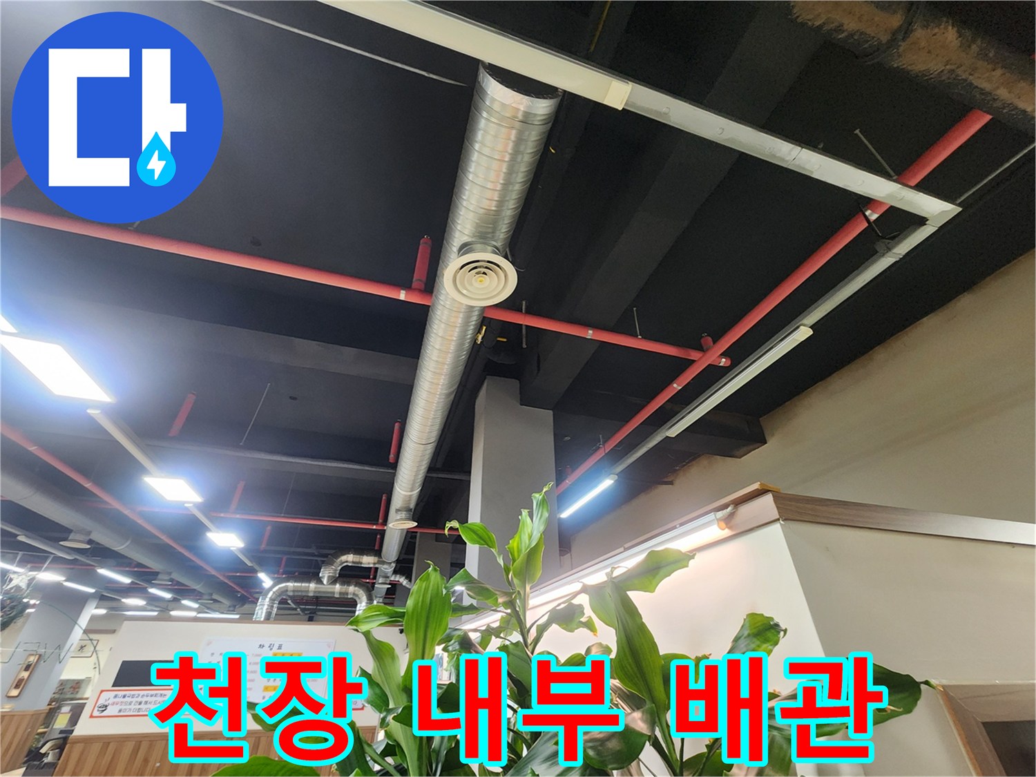 상업 공간 천장에 설치된 은색 덕트와 빨간색 배관