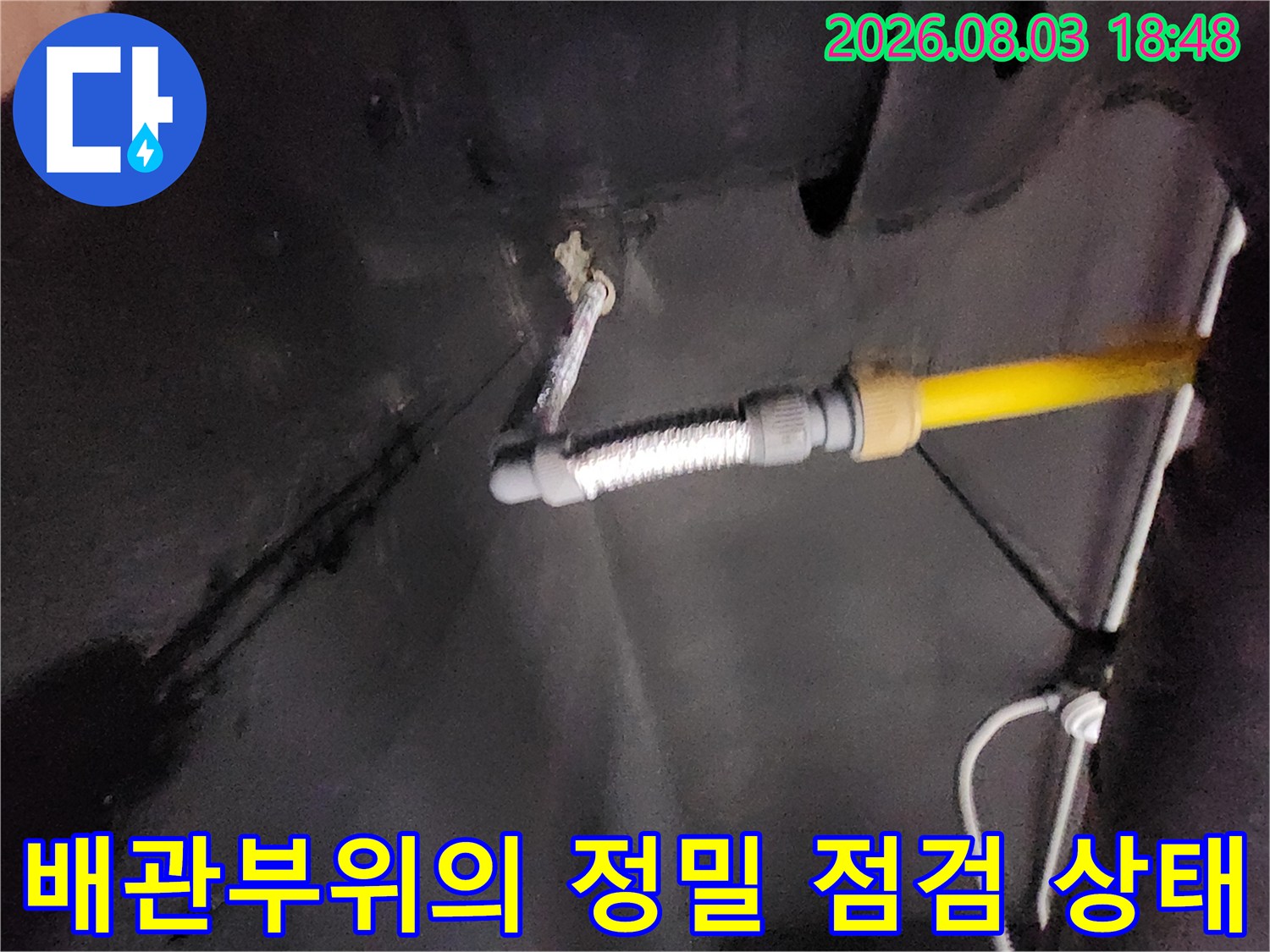 싱크대 하단의 노란색 배관과 연결 호스의 디테일 샷