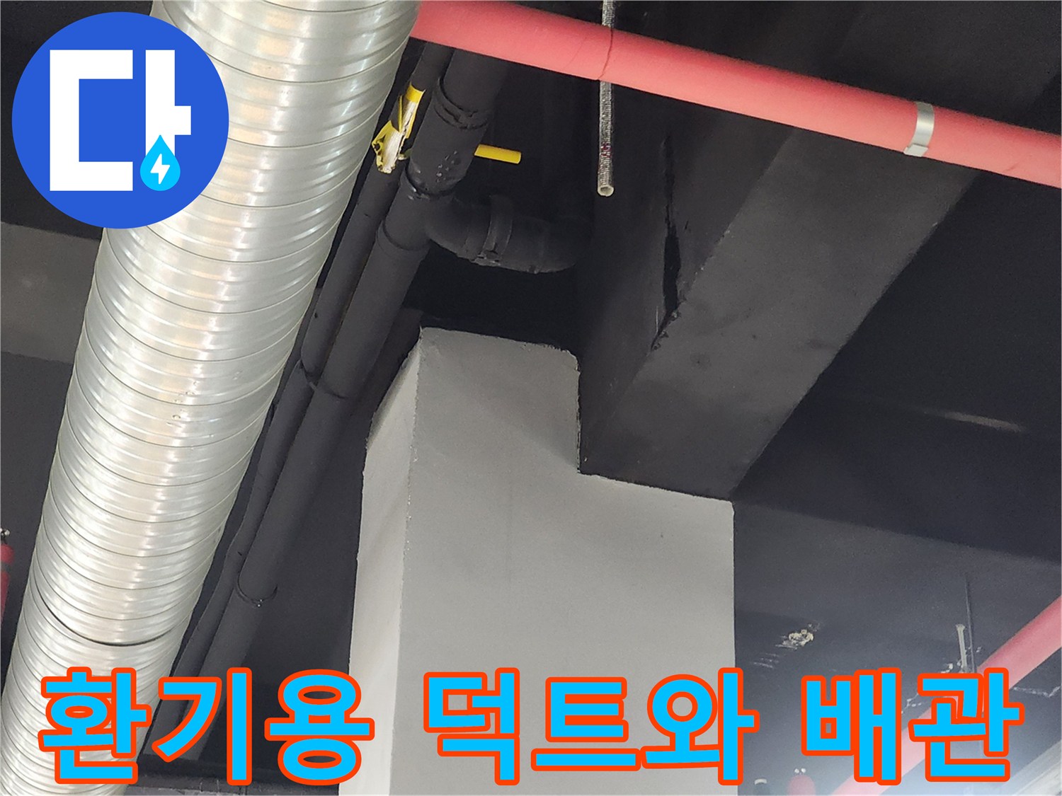 천장 구조물에 설치된 은색 환기 덕트와 붉은색 배관의 모습