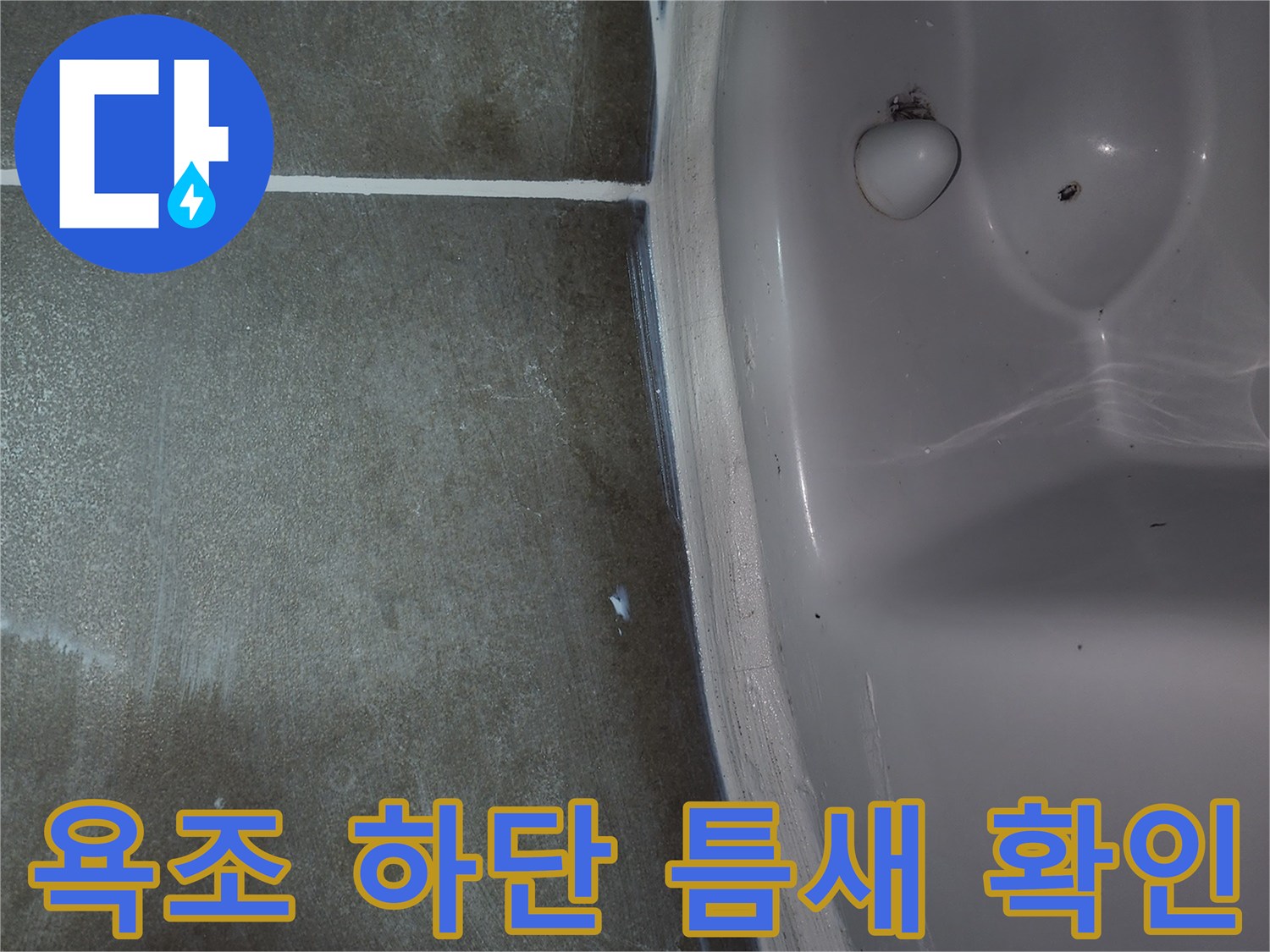 욕조와 바닥 타일 사이의 미세한 틈새를 점검하는 모습입니다.