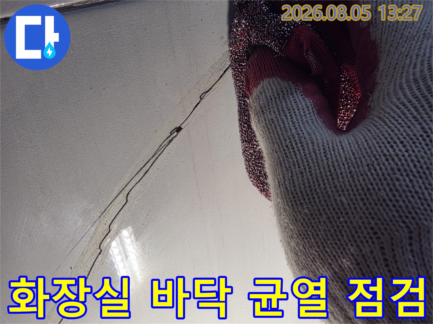 갈라진 화장실 타일과 메지 사이를 정밀하게 점검하는 모습