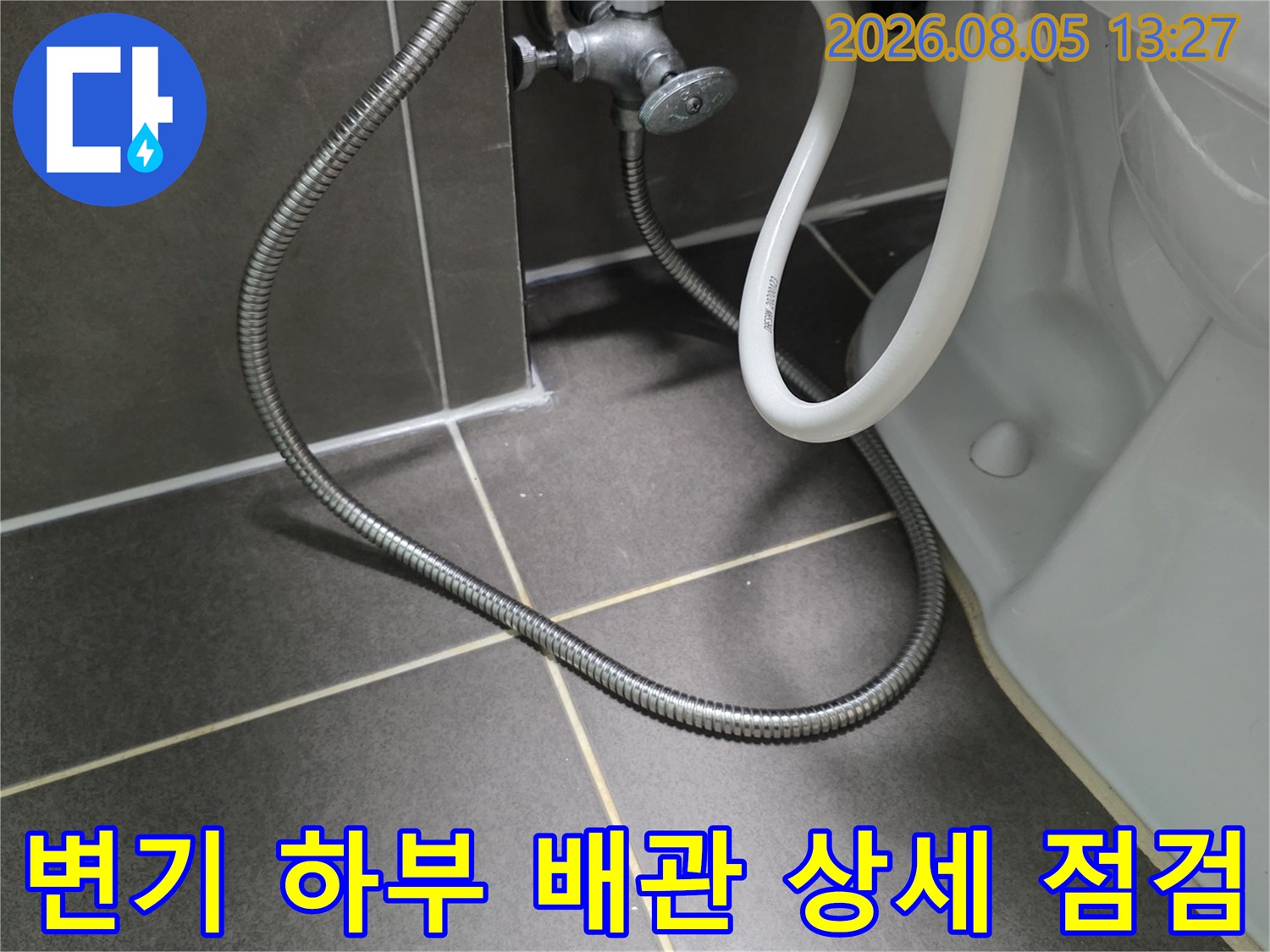 양변기 아래쪽에 위치한 급수 및 배수용 노출 배관 시스템을 확인하는 장면