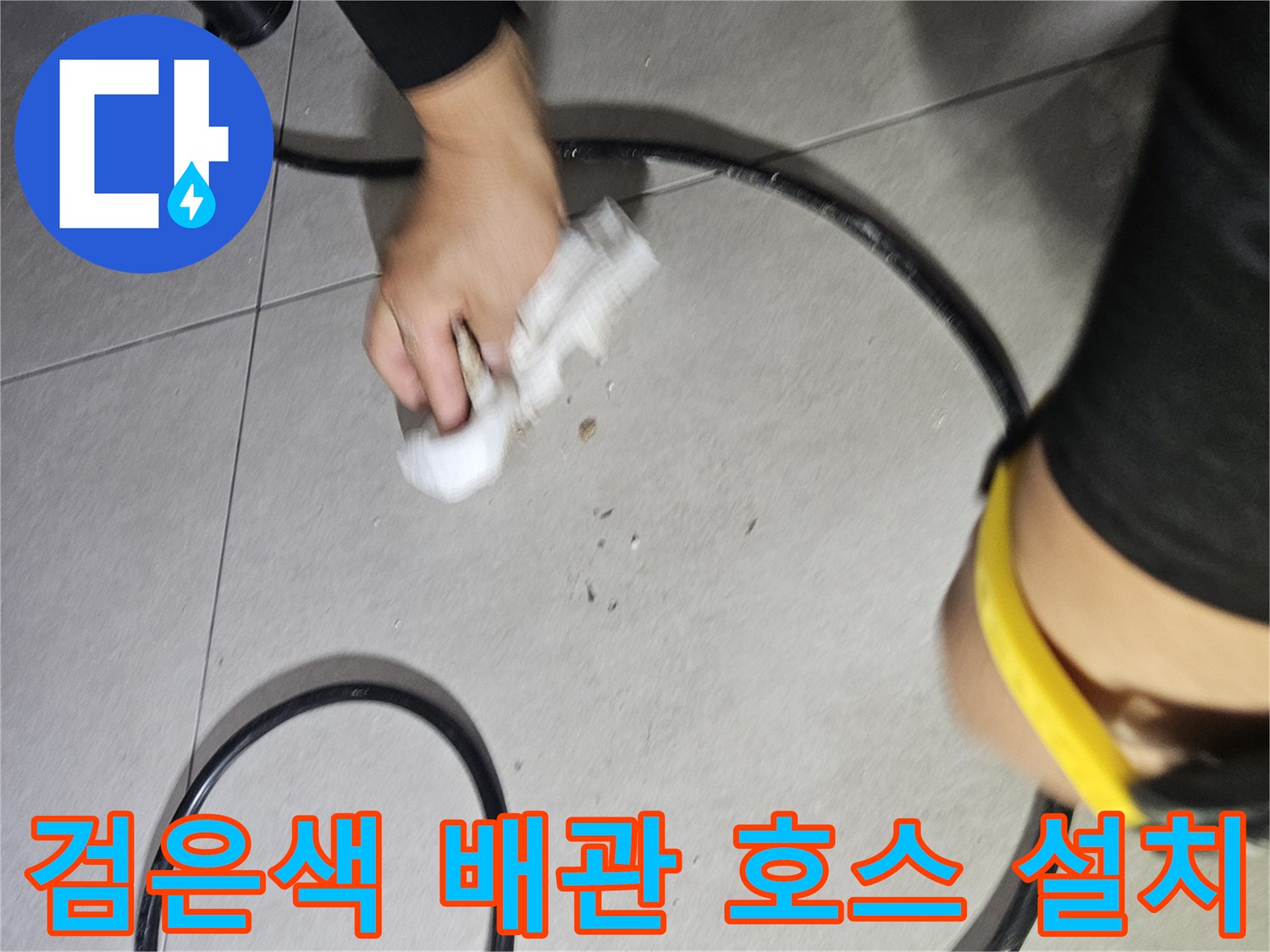 바닥 타일 위로 지나가는-압력 테스트용 검은색 호스