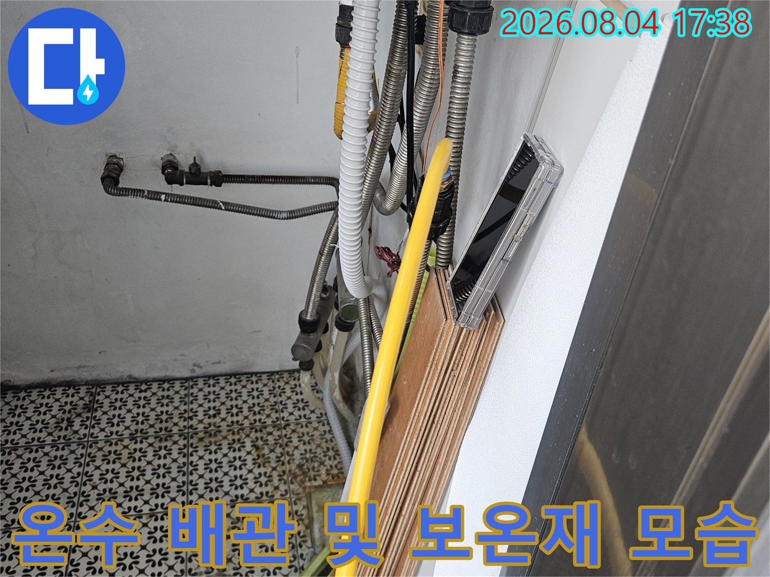 싱크대 밑 노란색 보온제로 감싸진 파이프의 전반적인 배치와 상태