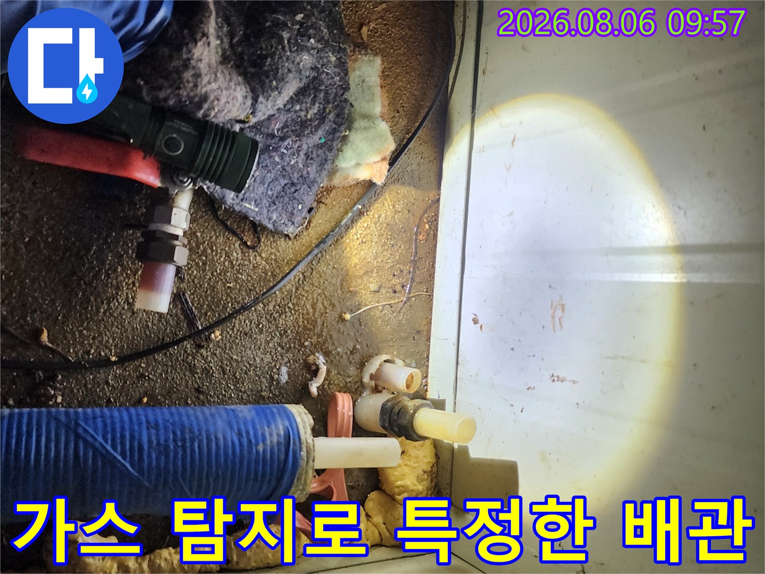 노란색 보온재로 덮인 수도 계량기 주변의 배관 수리 현장