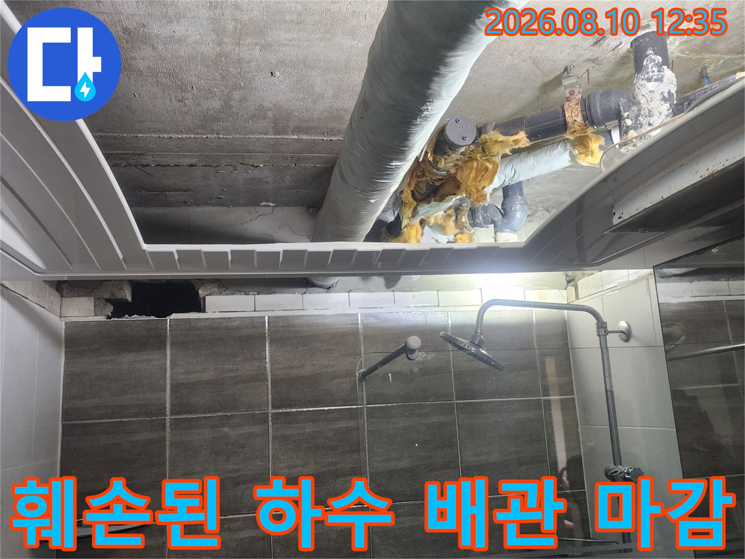 욕실 천장 내부의 낡은 하수 배관과 보온재 상태를 보여줍니다.