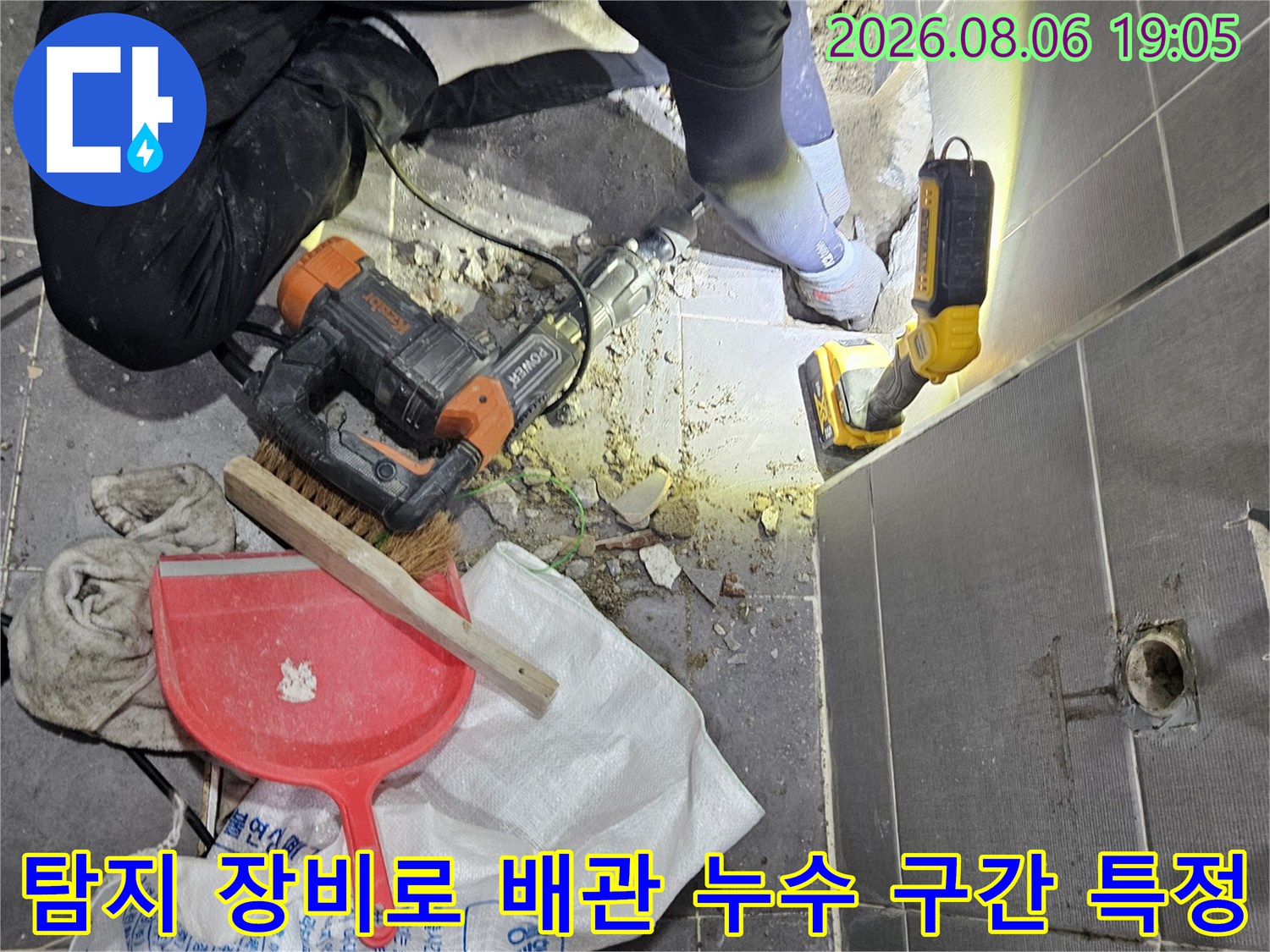 화장실 벽면 타일 뒤에 위치한 배관의 파손 부위를 전문 탐지기로 정밀 점검하는 모습