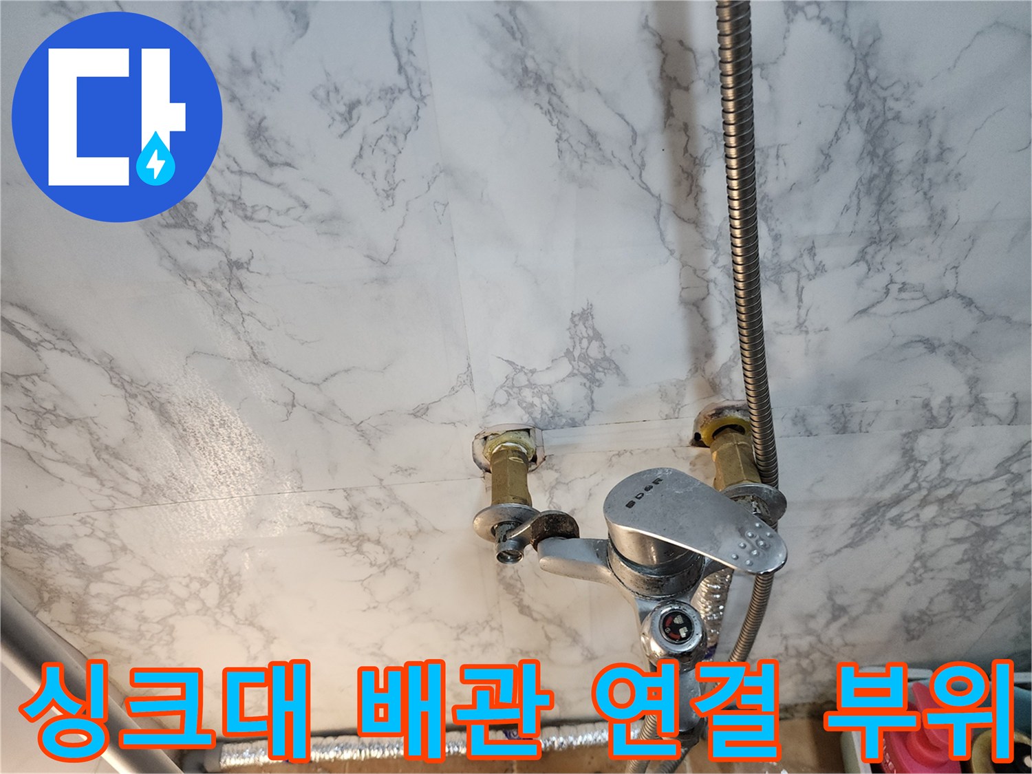 벽면 배관과 수도꼭지가 연결된 주방 내부 사진
