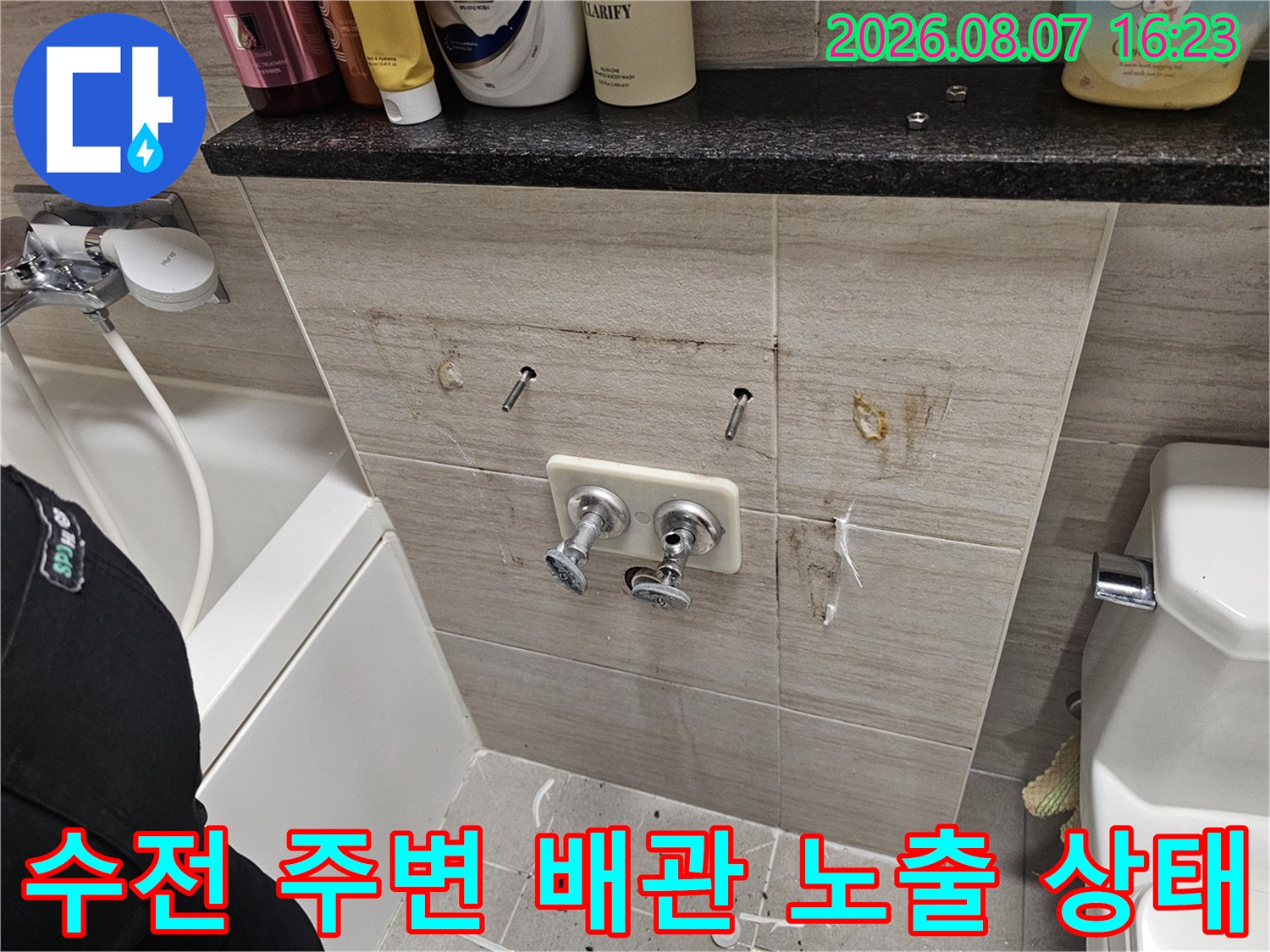 세면대 수전-연결 부위의 타일을 제거하고 내부 배관을 드러낸 사진입니다.