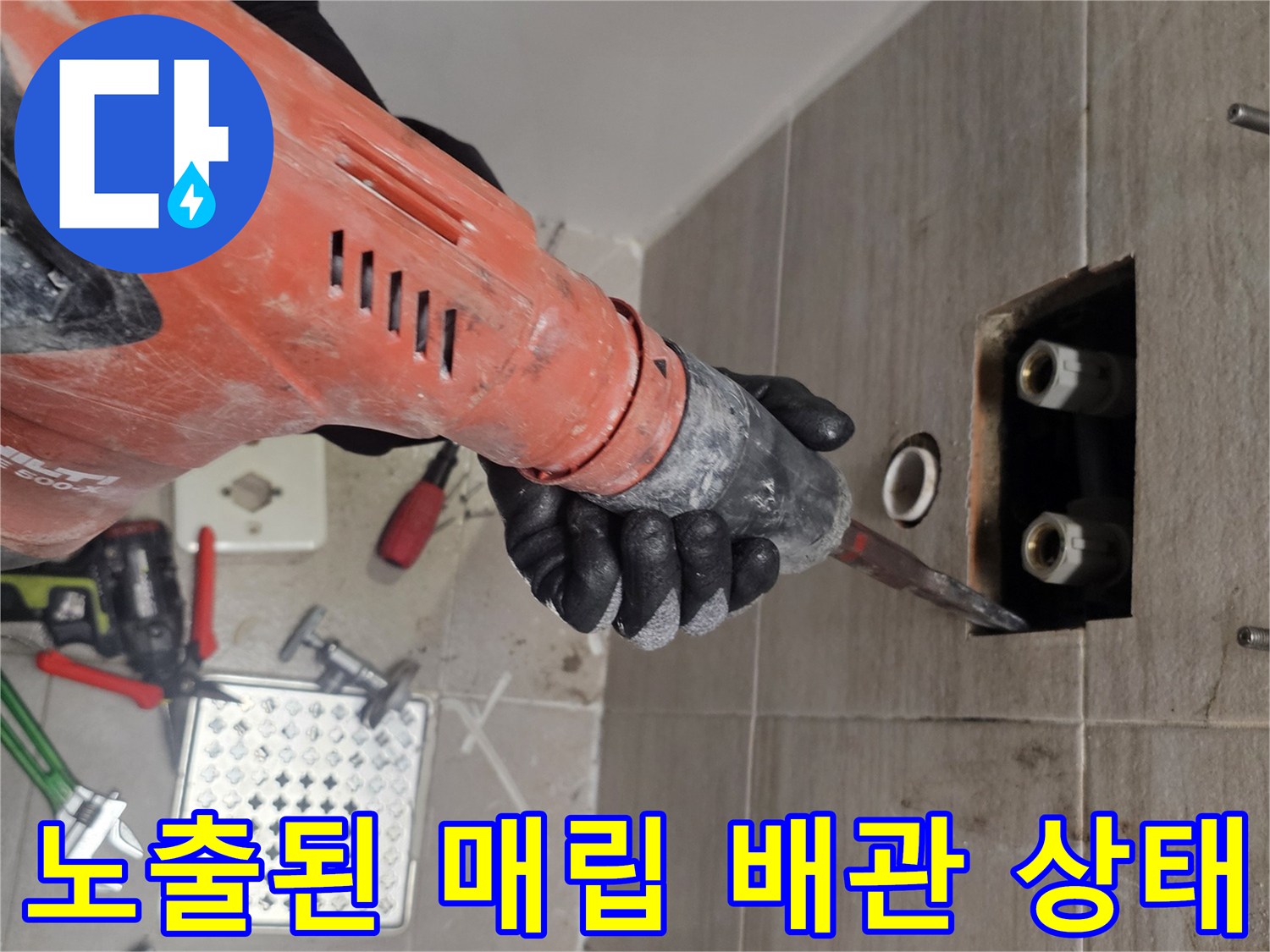 타일 제거 후 드러난 벽 내부의 급수 배관과 공구들