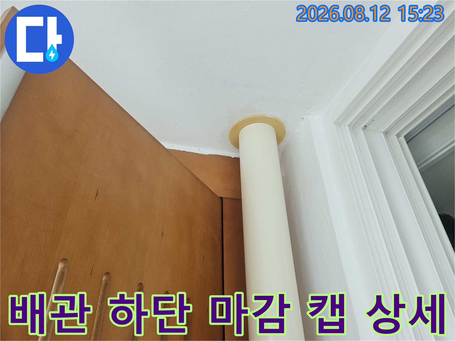 흰색 배관 하단에 설치된-베이지색 원형 플라스틱 마감재