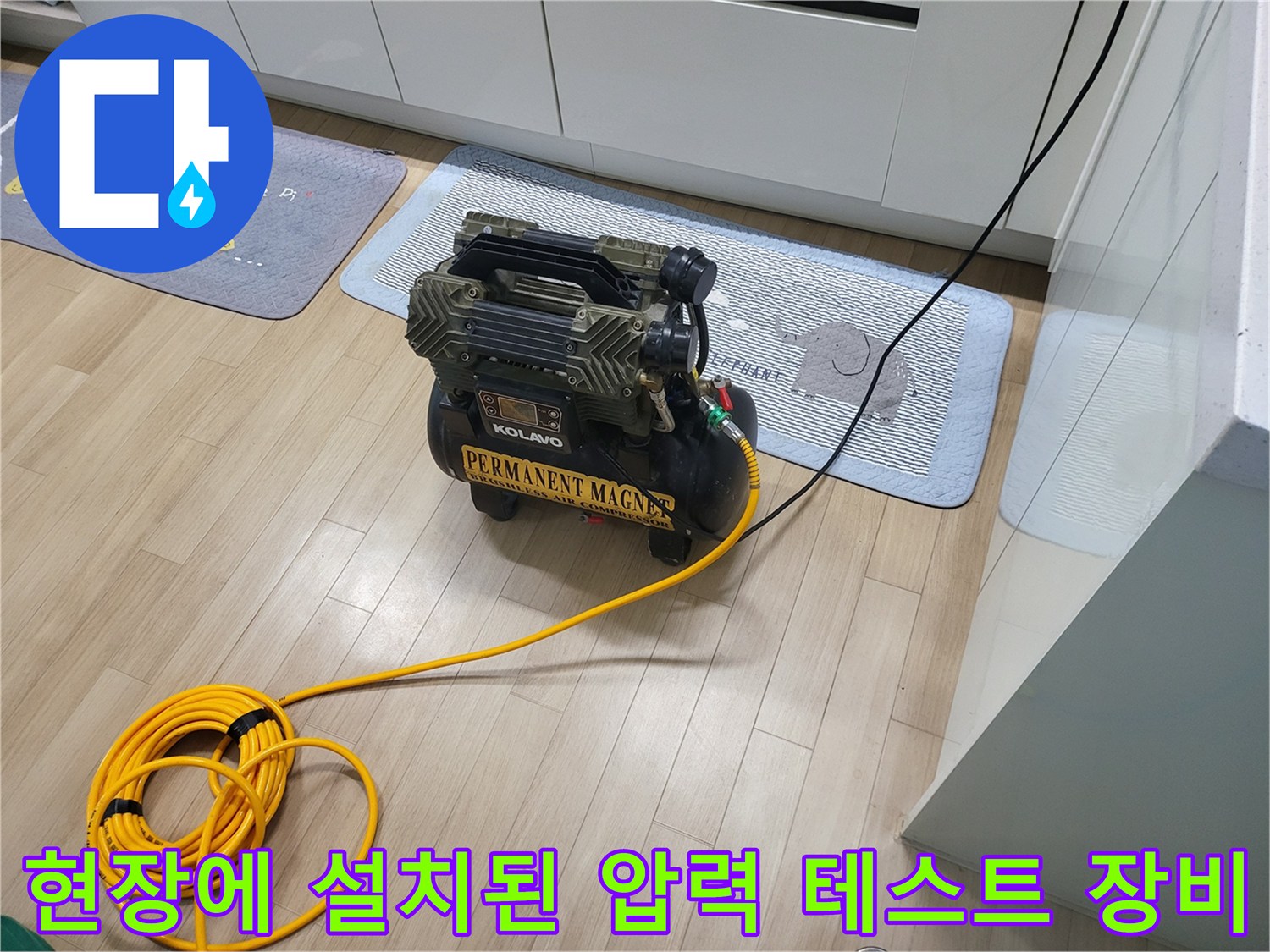 바닥에 놓인 에어 컴프레이셔와 노란색 공압 호스 연결 상태