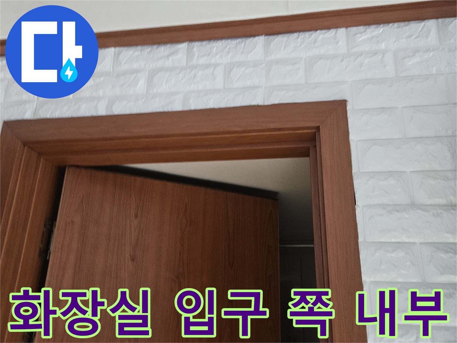 문 안쪽으로 보이는 나무 도어와 타일 벽면 상세