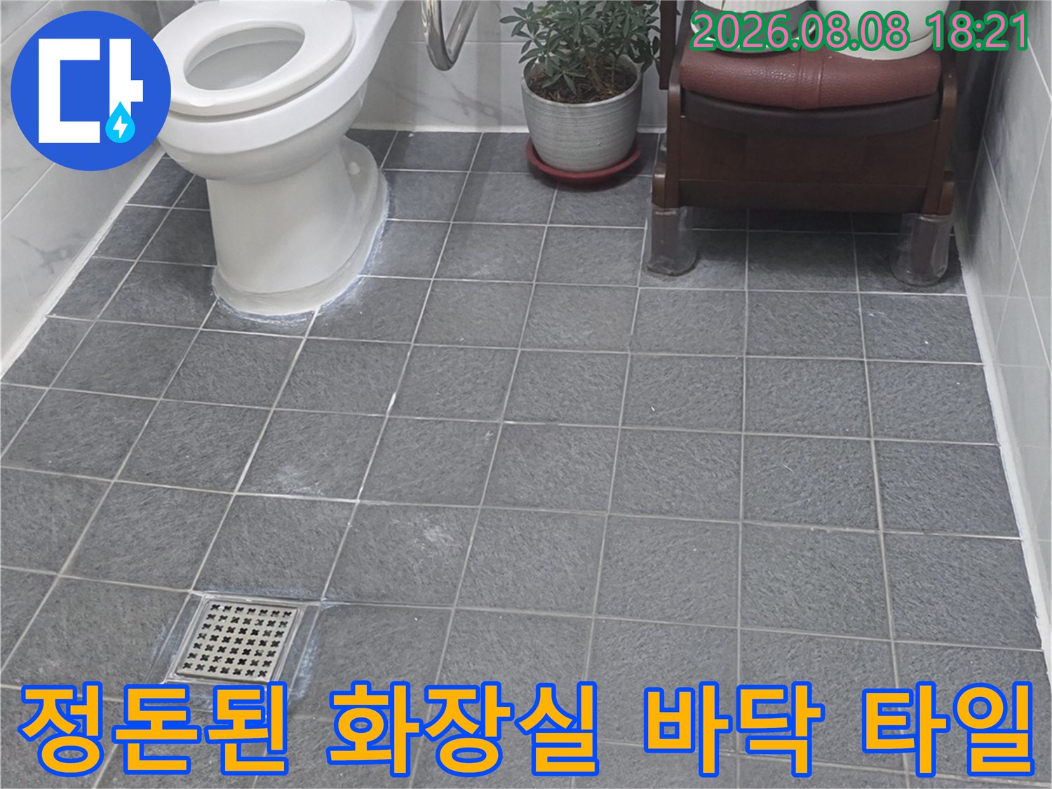 회색 타일 바닥과 변기가 배치된 욕실 내부 사진입니다.