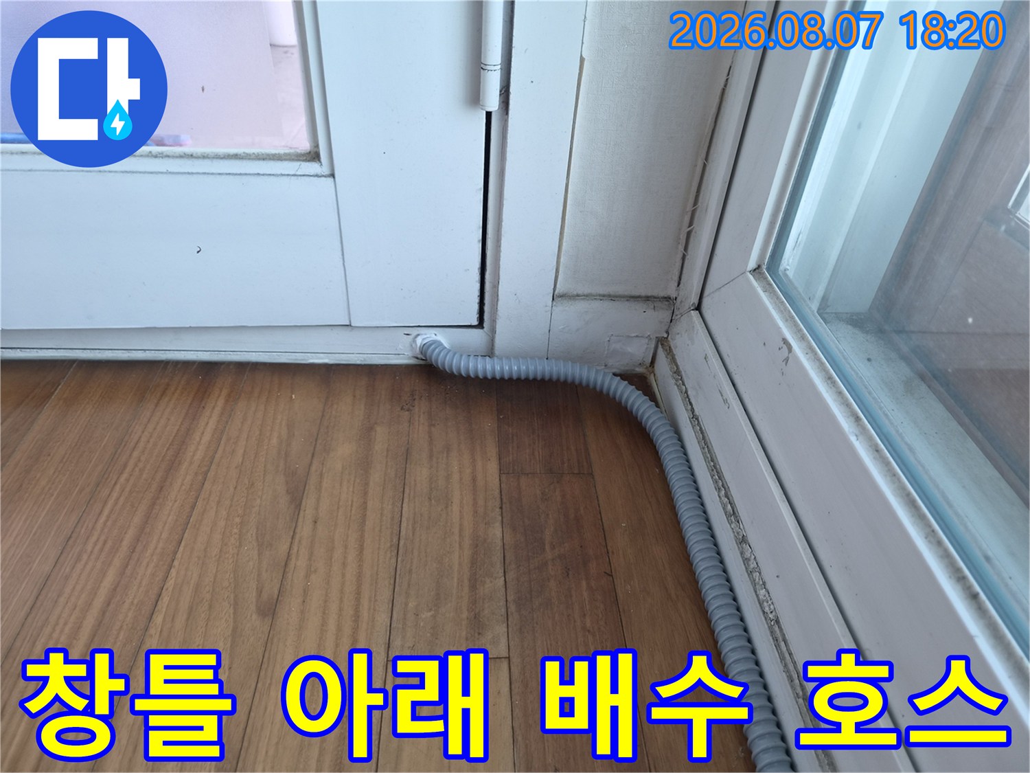 하얀색 창문 틀과-회색 에어컨 배수관 연결 부위