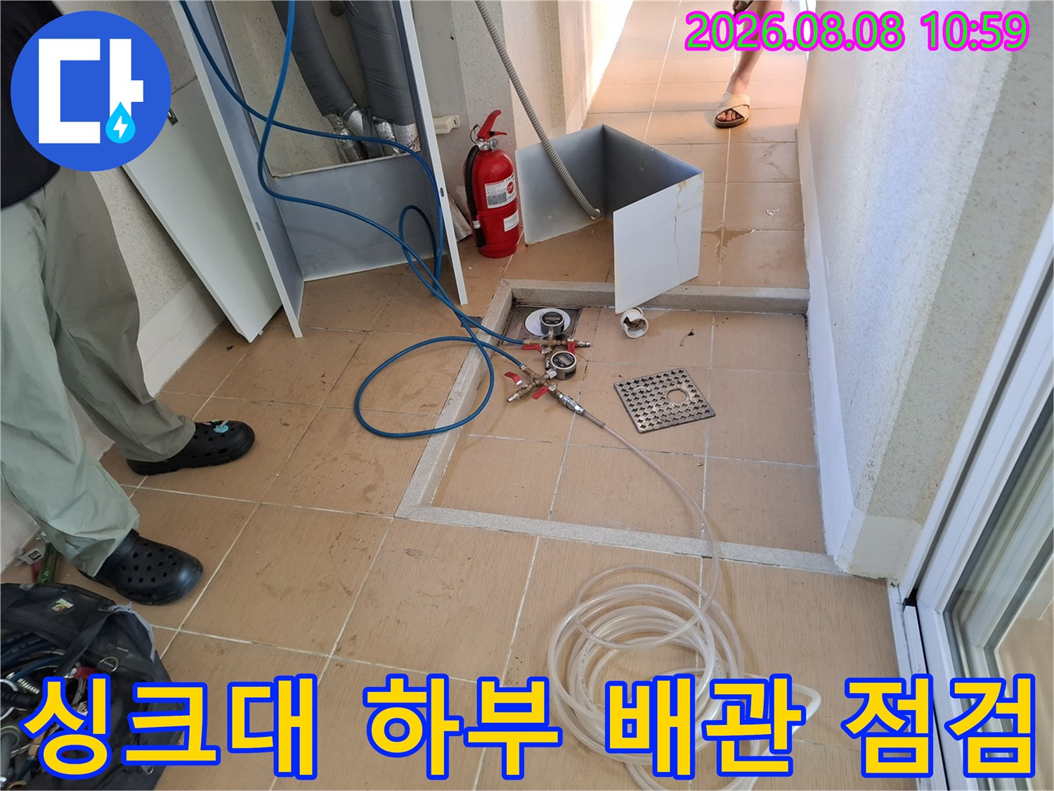 성동구 금호동 아파트 싱크대 하부 배관에 공압 검사 장비를 연결하여 누수 여부를 확인하는 모습입니다.
