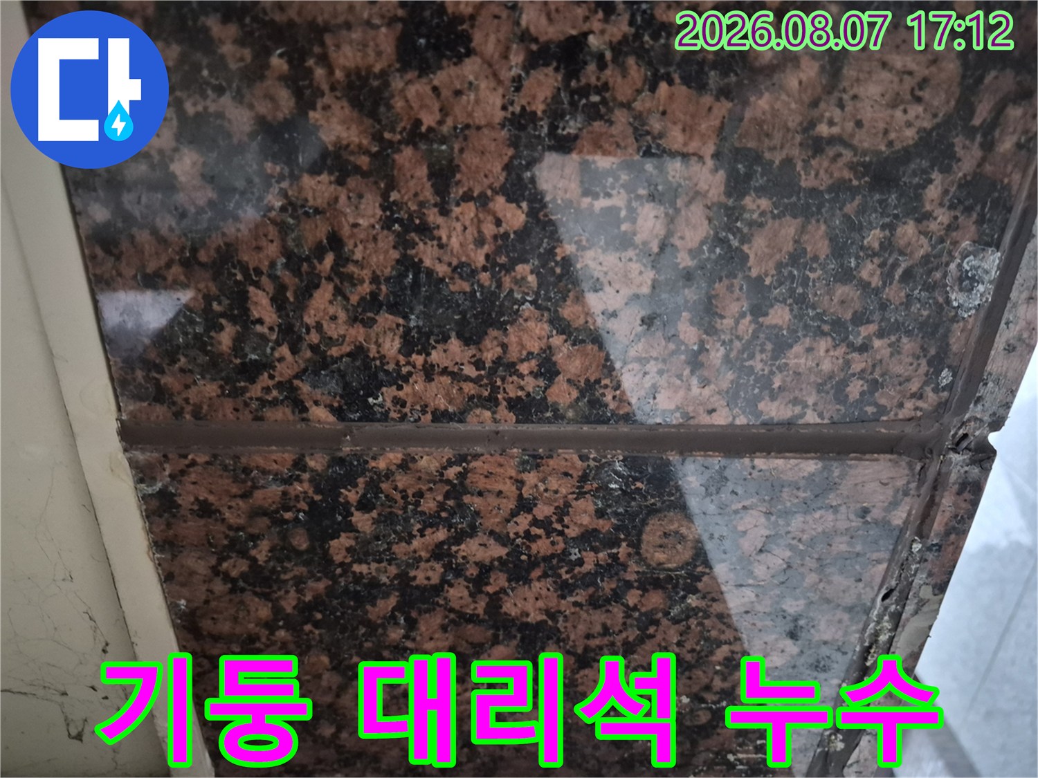 건물 기둥의 대리석 마감재 사이 누수 흔적 확인