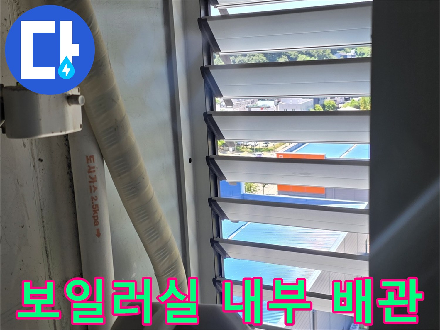 창문 아래 배치된 보일러 관련 배관들의 근접 촬영