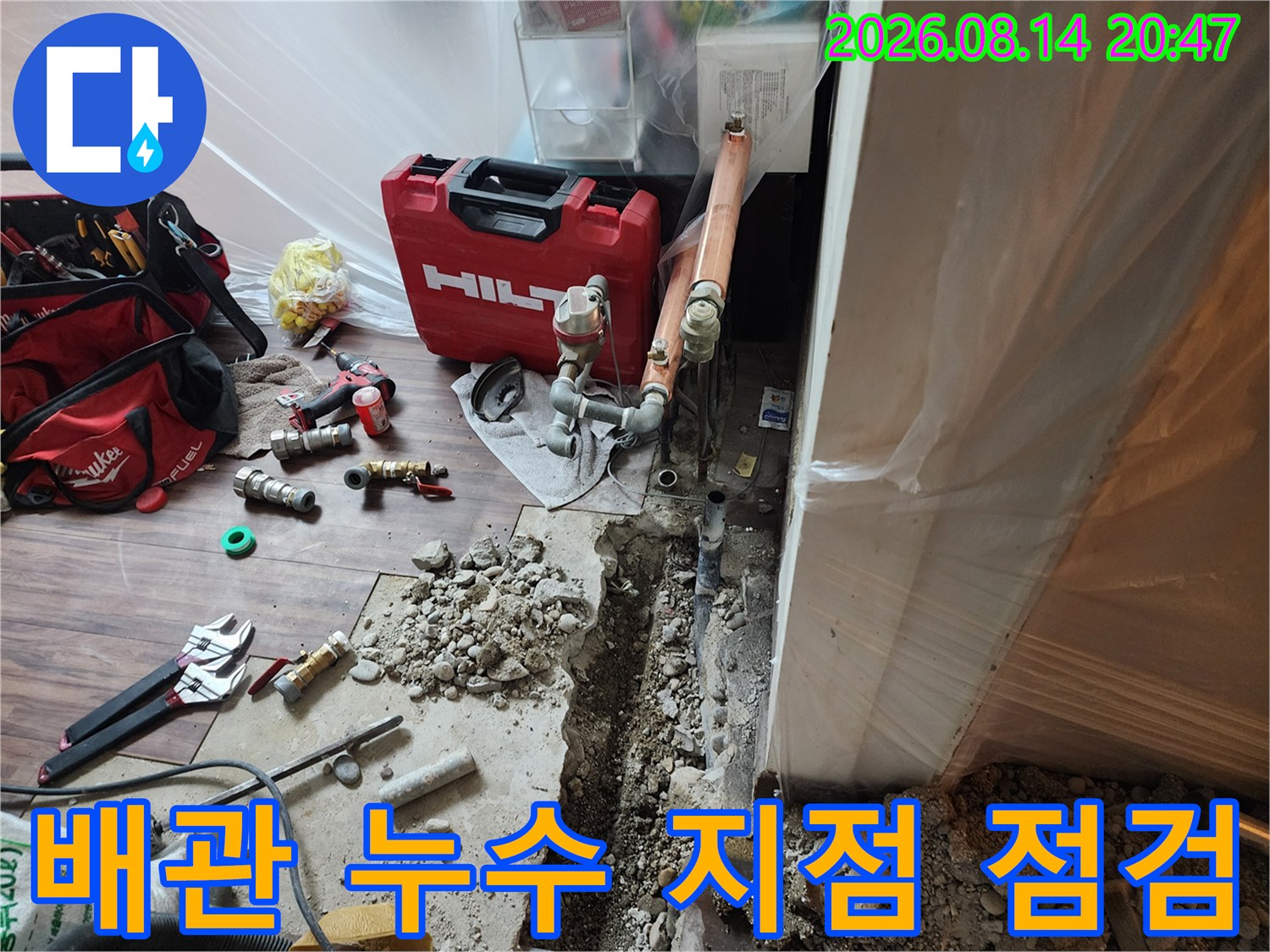 굴착된 바닥 사이로 보이는 노출된 수도 배관과 작업 도구들 - 누수 확인 단계