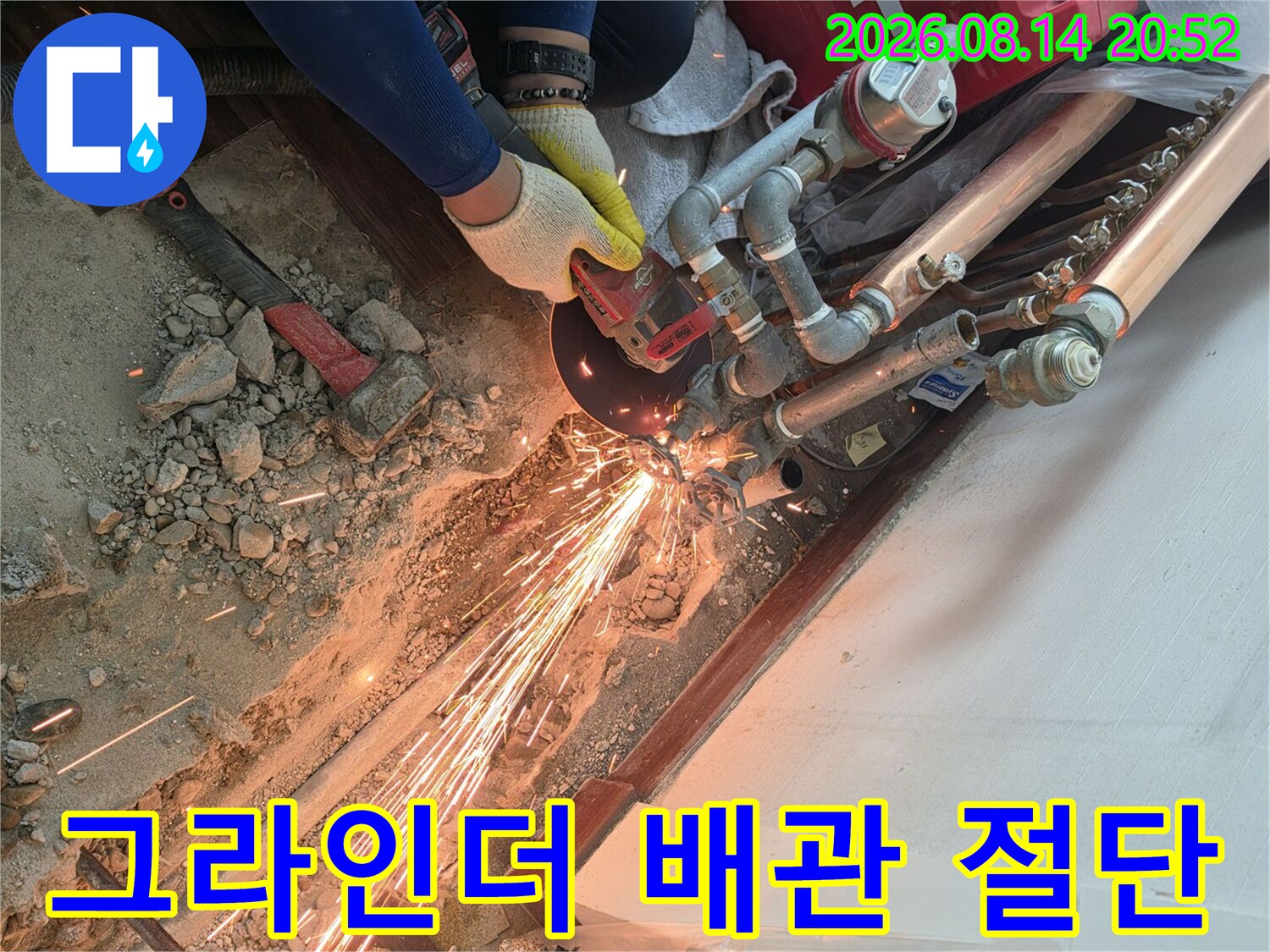 배관 수리를 위해 그라인더로 기존 관을 자르는 모습입니다.