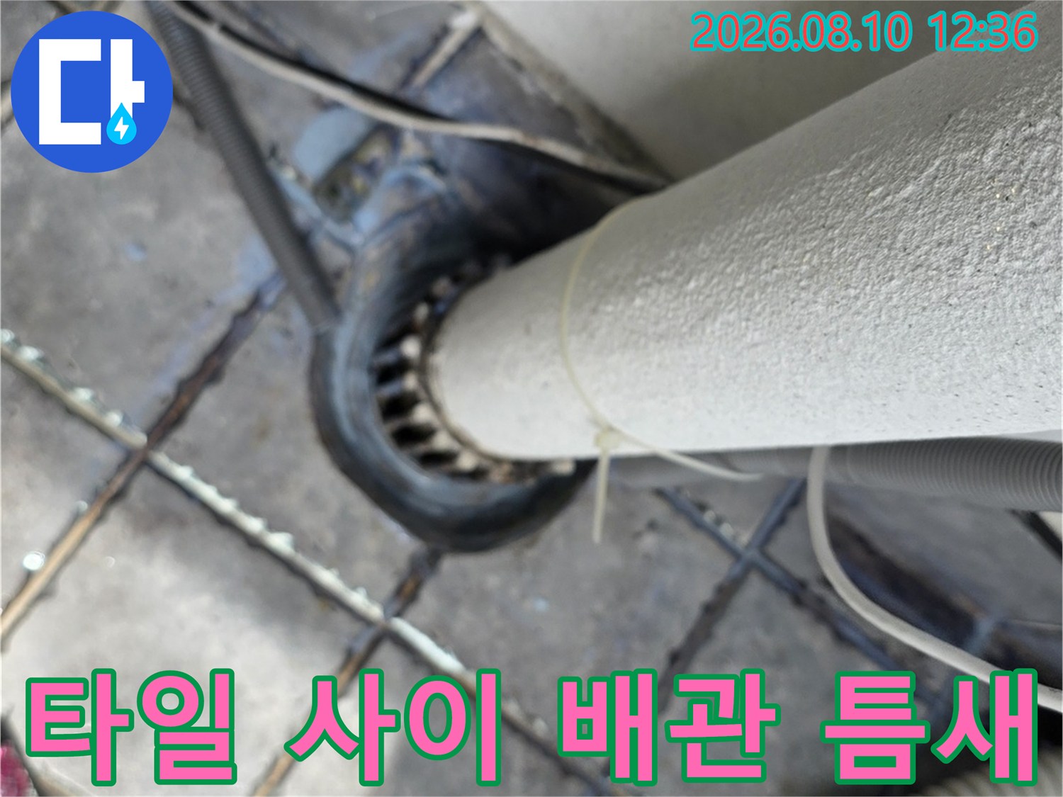 배관 주변 타일 사이의 벌어진 틈-누수가 의심되는 지점을 근접 촬영한 사진입니다.