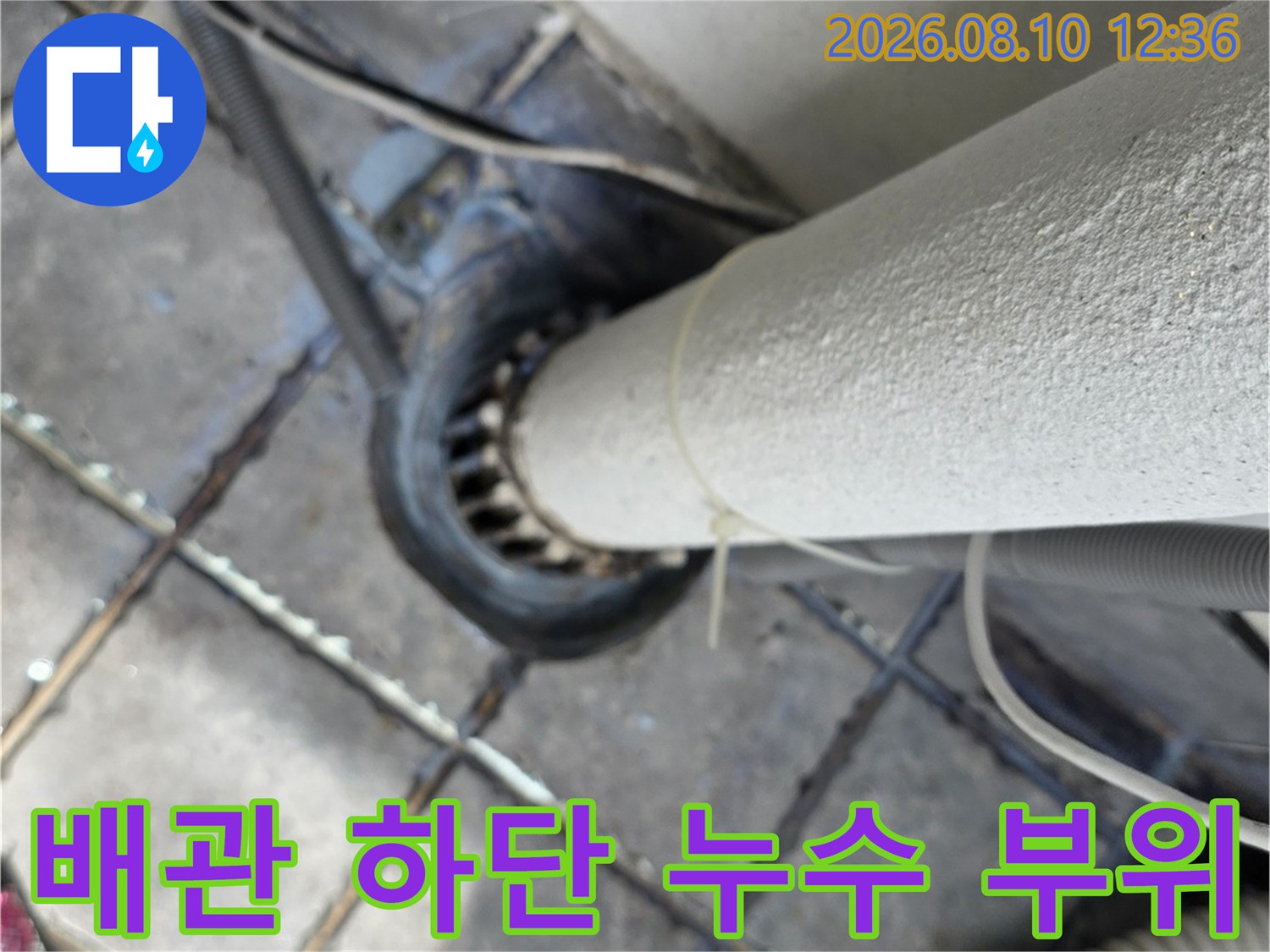 배관과 타일 경계면의 누수 흔적을 보여주는 근접 사진입니다.