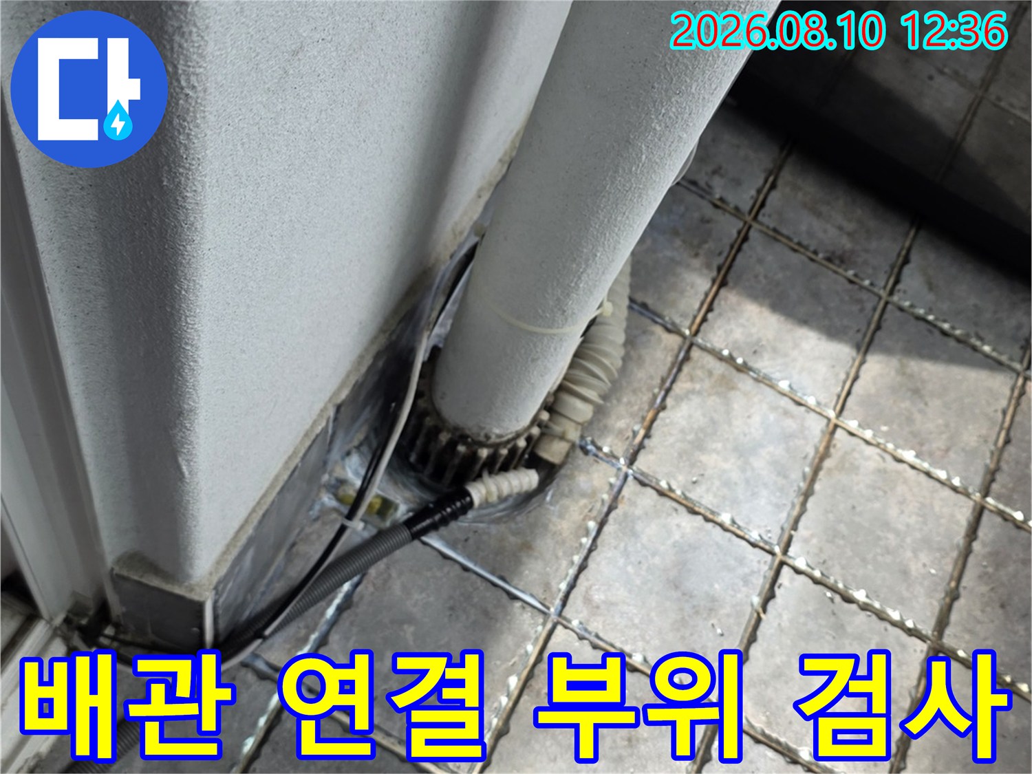 베란다 바닥 타일과 흰색 배관의 접합 상태 확인 사진