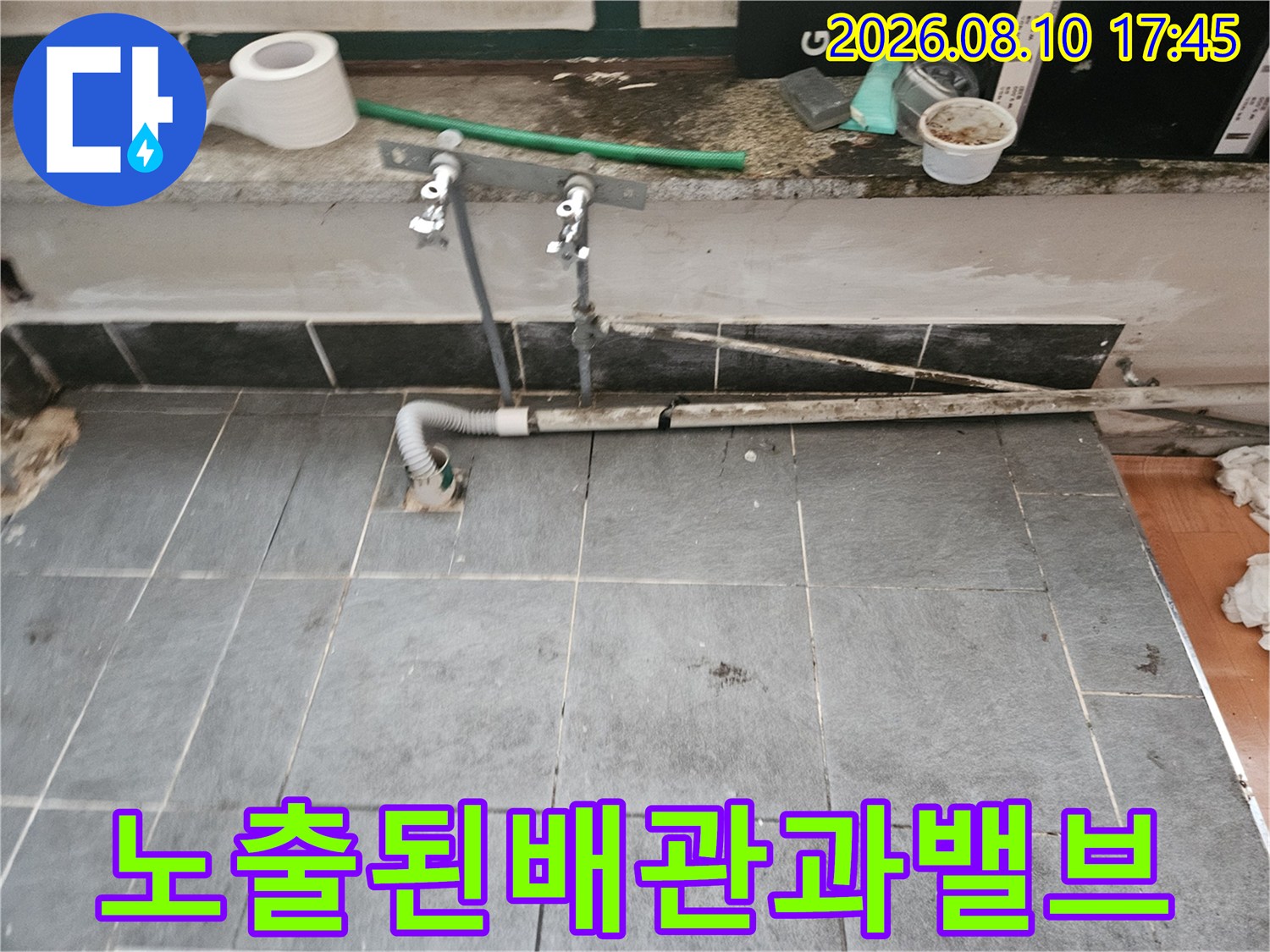 벽면에서 뻗어 나온 배관과 수도 조절 밸브의 모습입니다.