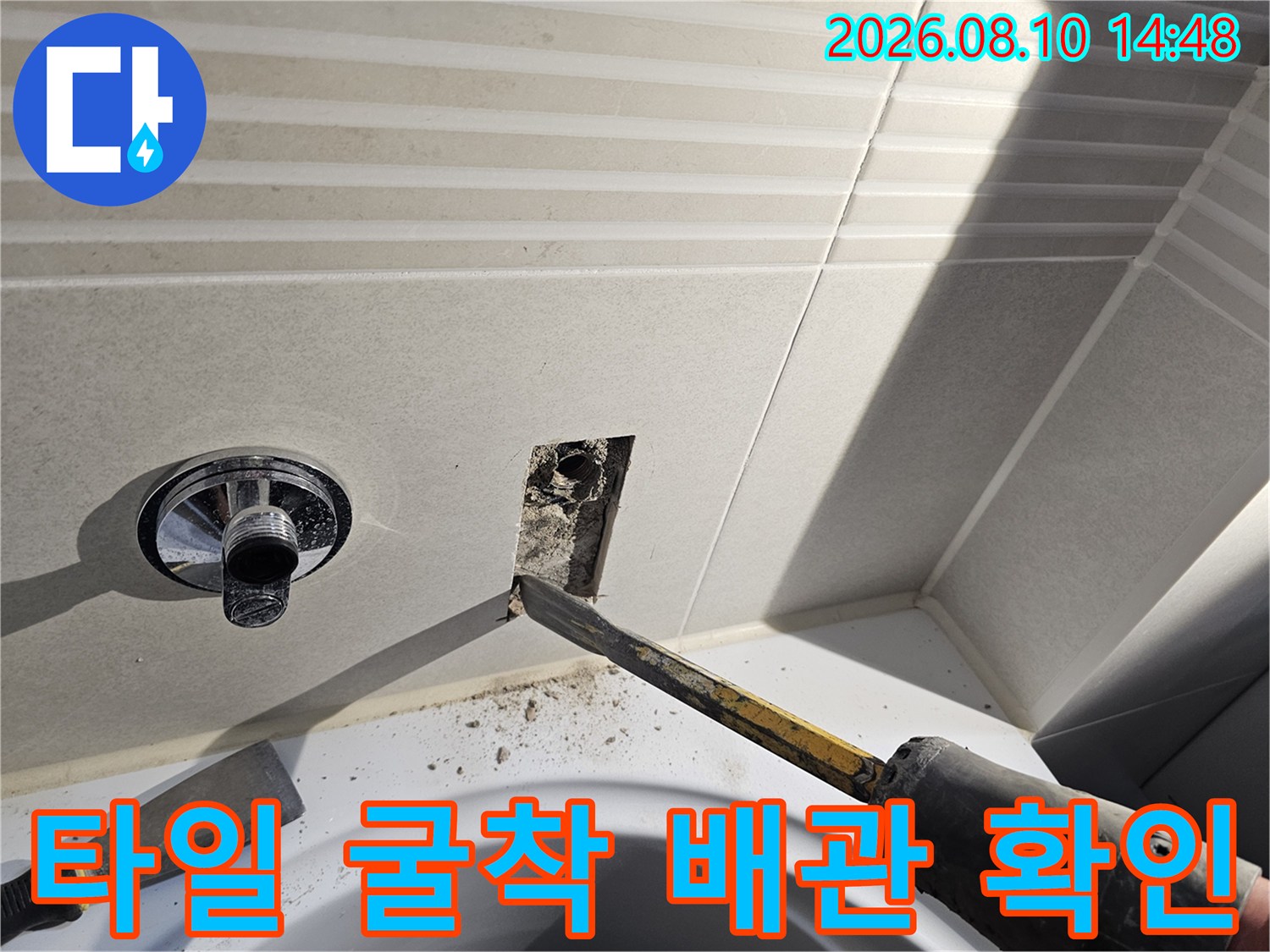 수전 옆 타일을 제거하여 매립된 배관을 노출시킨 공사 현장입니다.