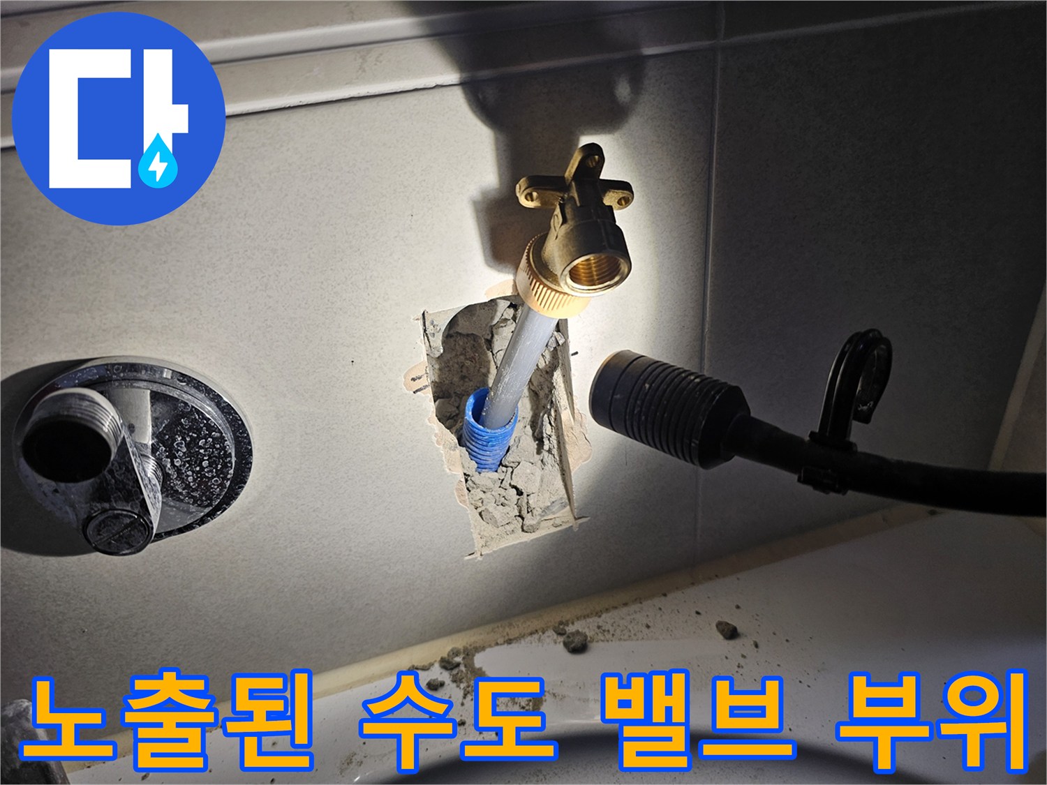 타일 제거 후 드러난 금속 소재의 수도 밸브와 배관 연결부