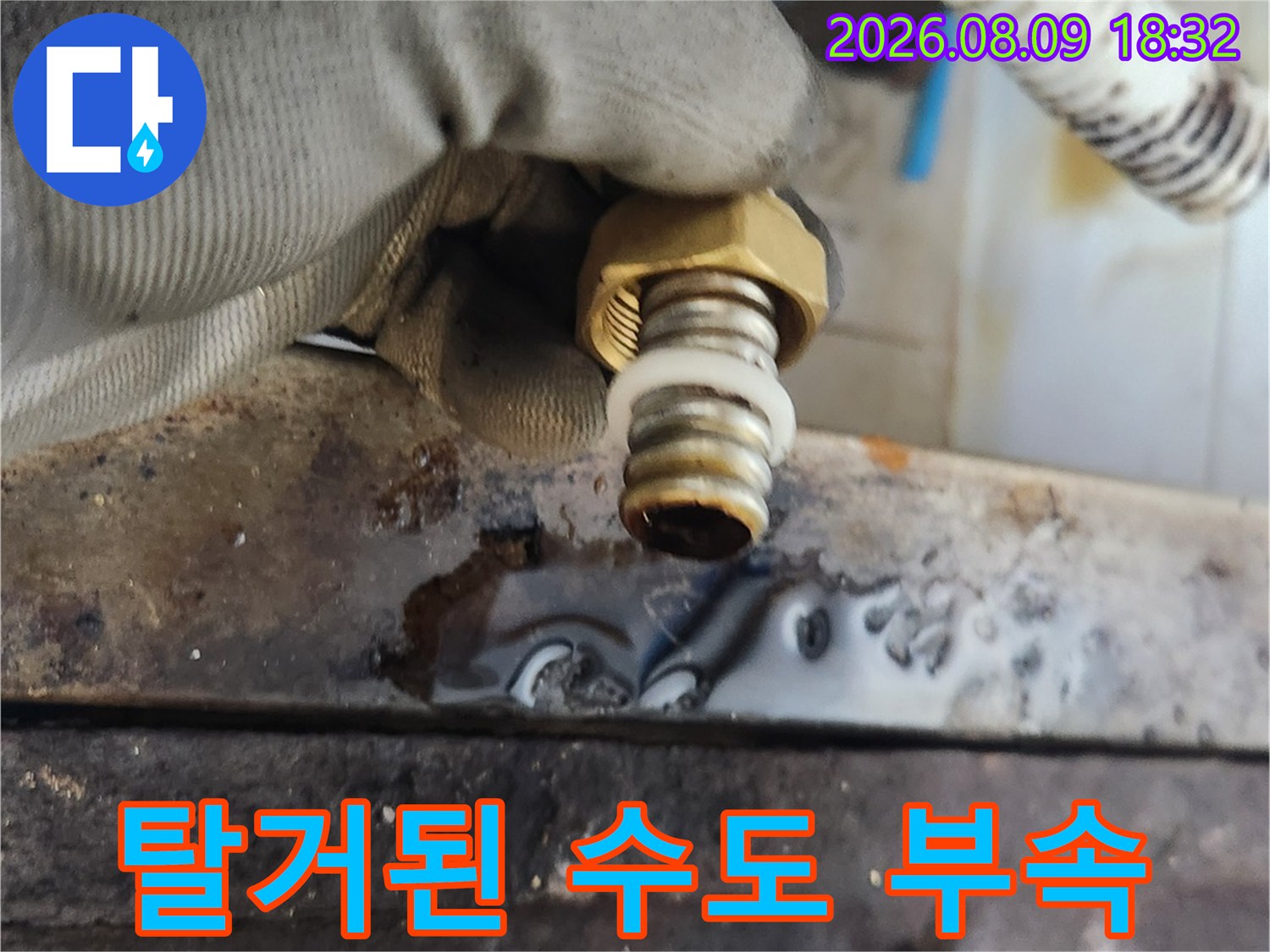 금속 재질의 앵글밸브와 연결 호스를 손으로 잡고 점검하는 장면