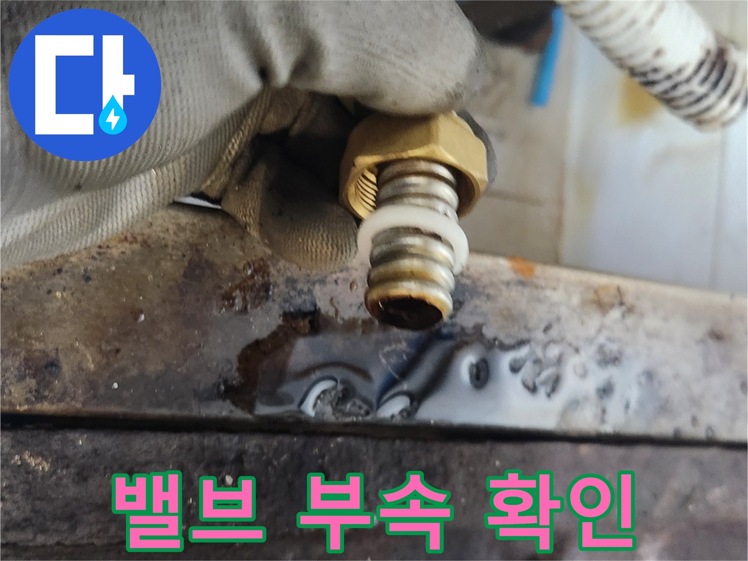 장갑을 낀 작업자가 새 배관 부속의 상태를 점검하는 장면