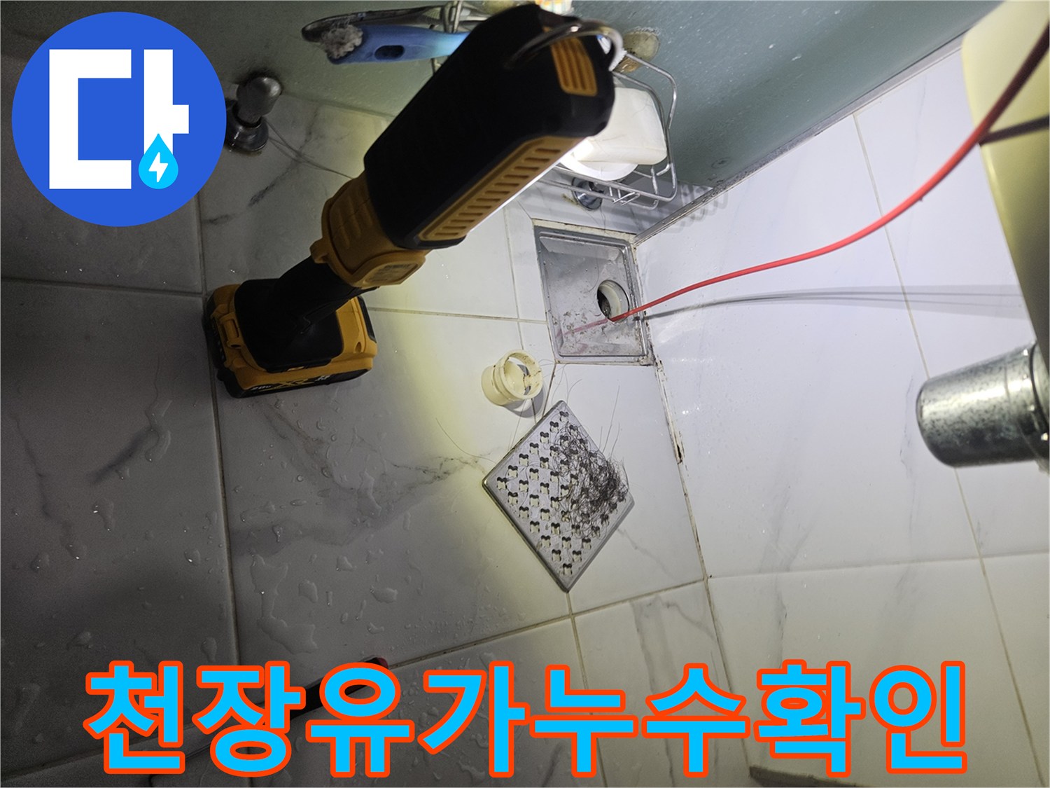 오염된 화장실 천장 배수구 유가와 작업용 전동드릴이 놓여 있는 모습