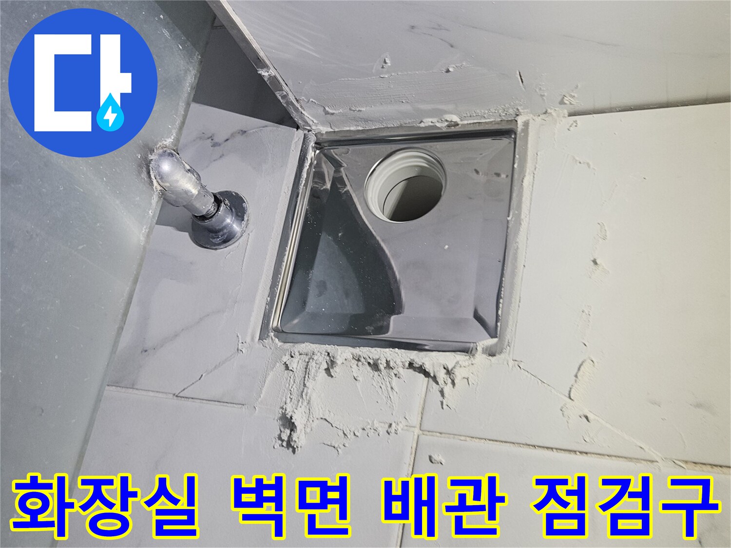 화장실-벽면-타일-사이에-설치된-배관-점검구와-하단-수전-모습