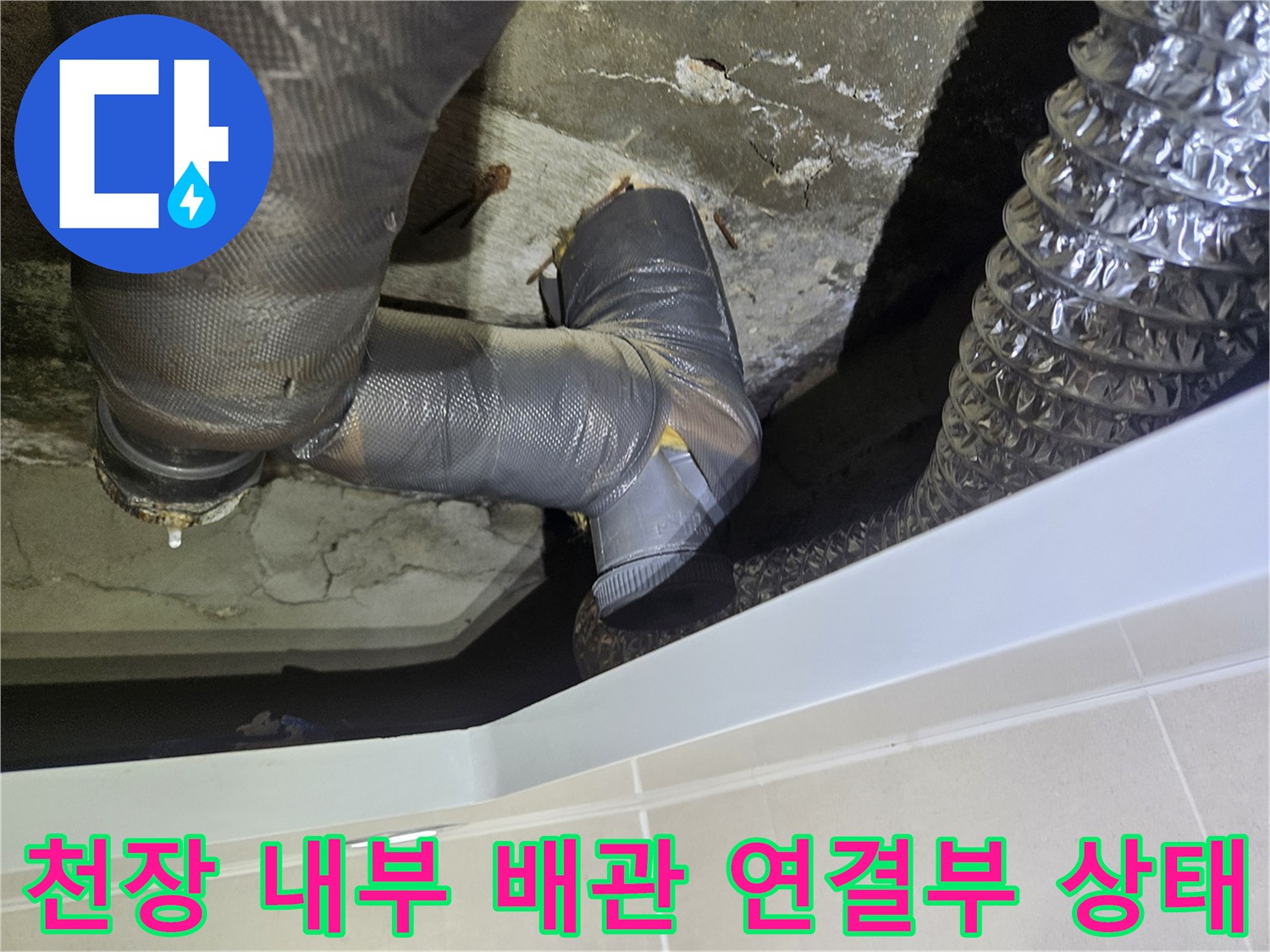 화장실-천장-내부의-회색-배관과-은색-자바라-호스가-연결된-모습