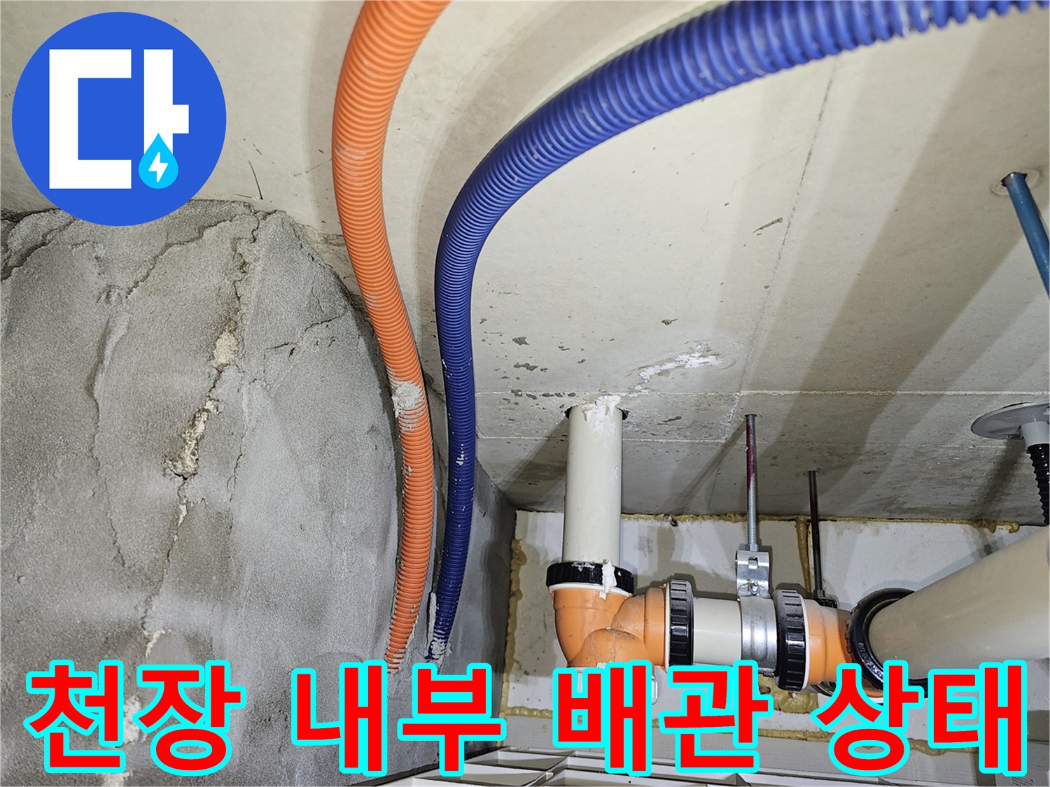 천장 내부의 오렌지색 및 파란색 관로와 젖어 있는 벽면 부위