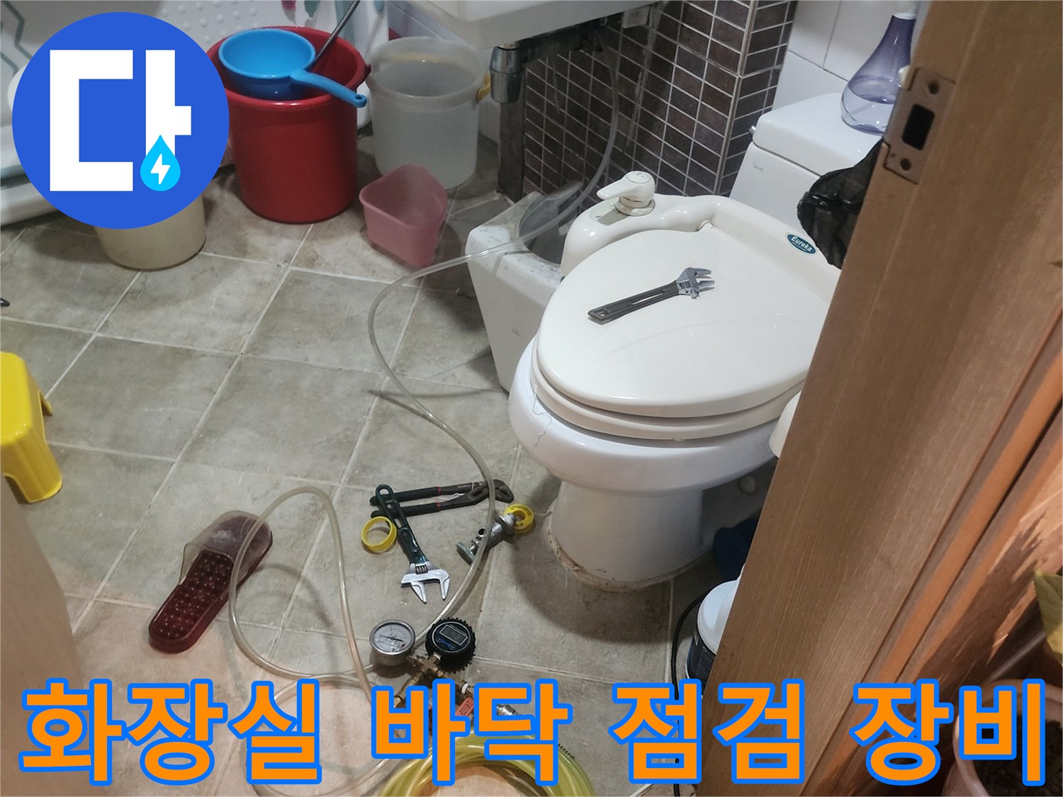 안산 부곡동 현장의-화장실 바닥에 놓인-배관 점검용 압력계와 호스