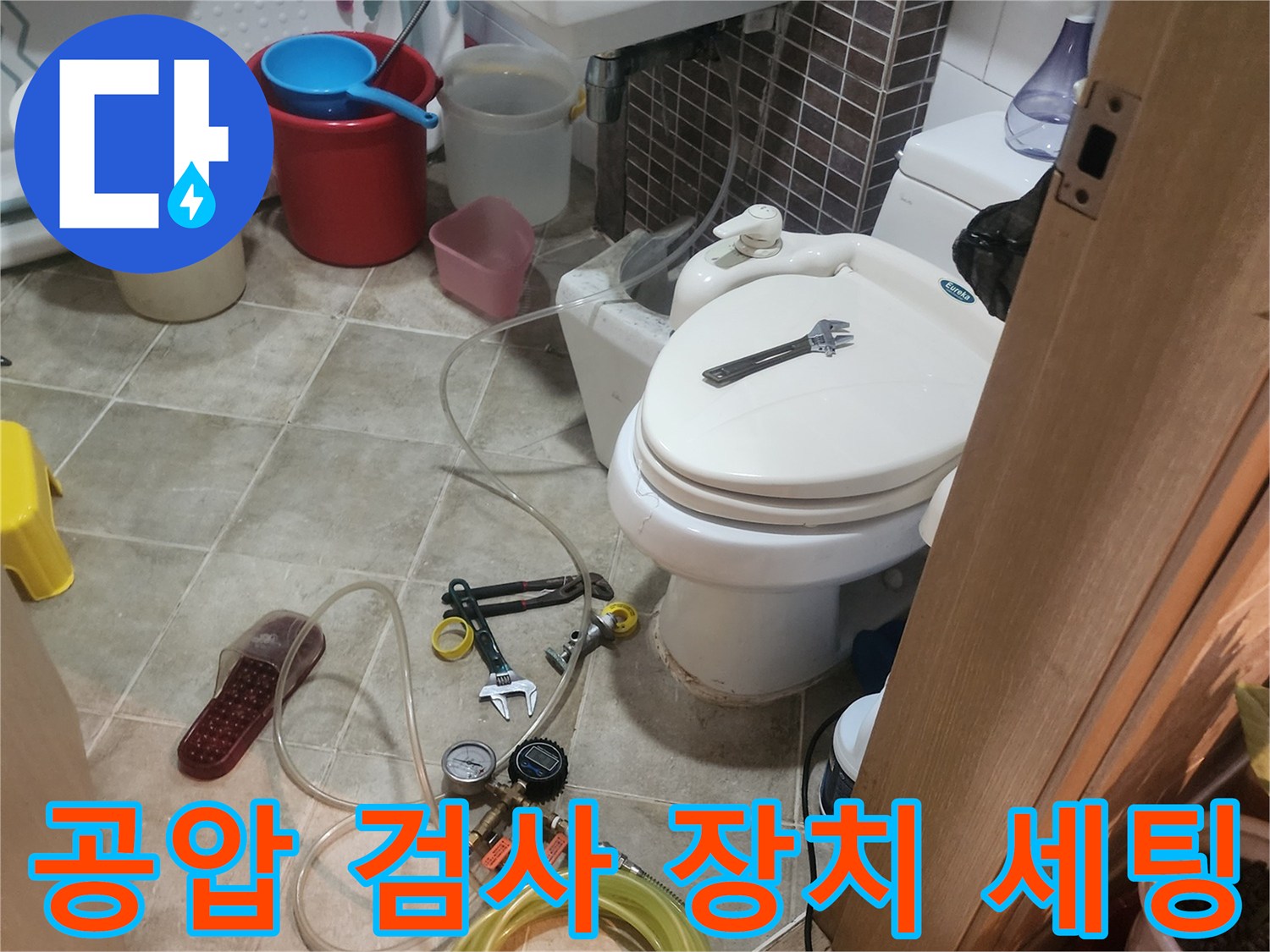 화장실 타일 바닥의-배관 누수 확인을 위한-압력계와 호스 뭉치