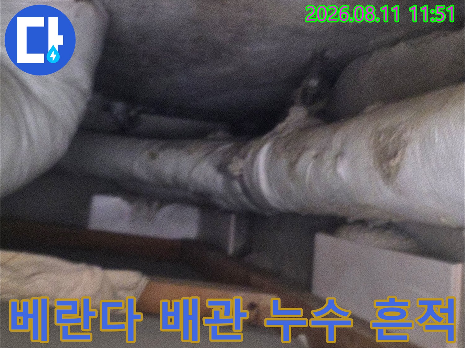 아파트 베란다 천장-배관 주변의 곰팡이와 습기 흔적을 확인하는 모습