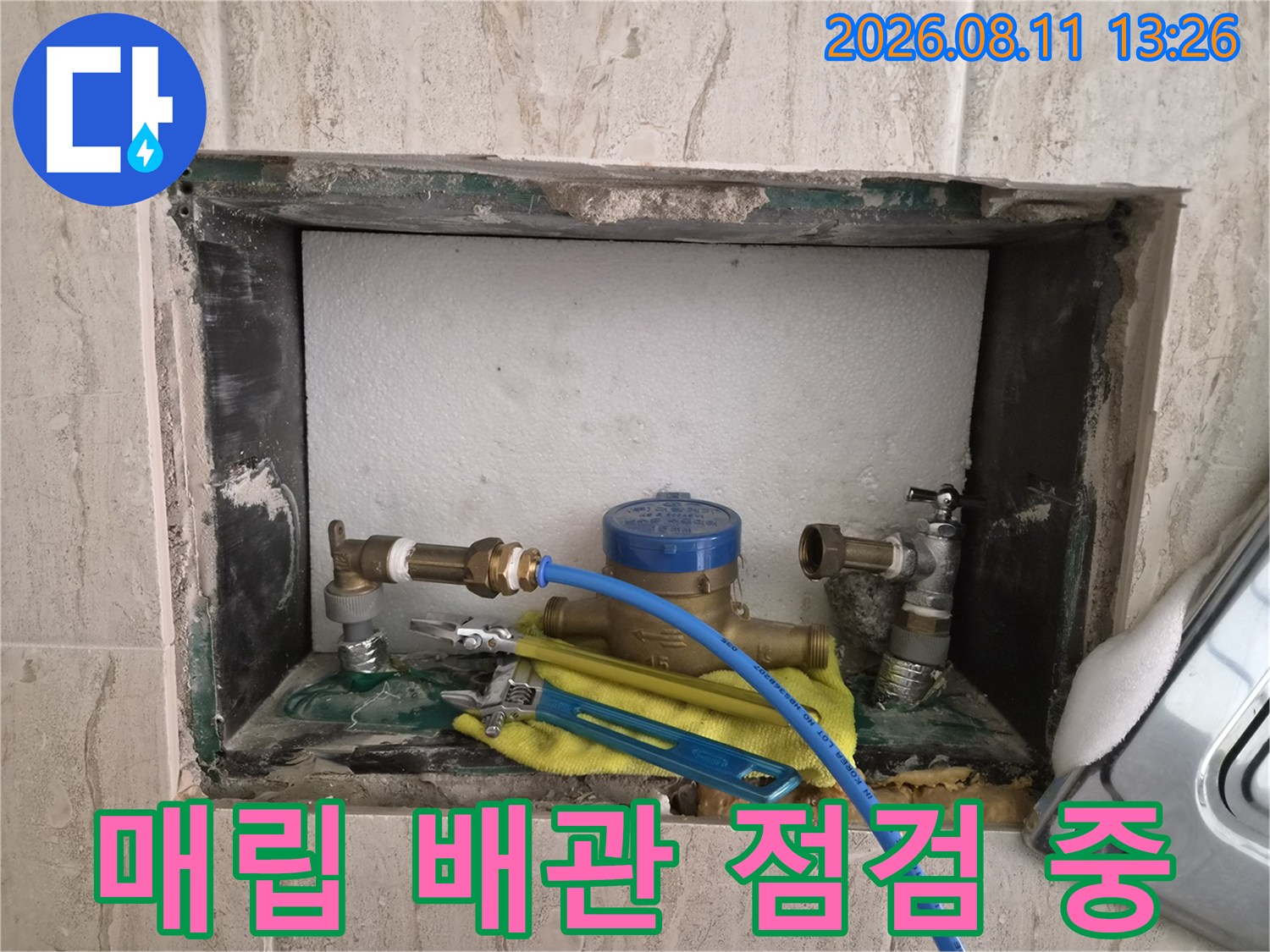 벽면 타일 파쇄 후 드러난 앵글밸브와 파란색 압력계 연결 배관