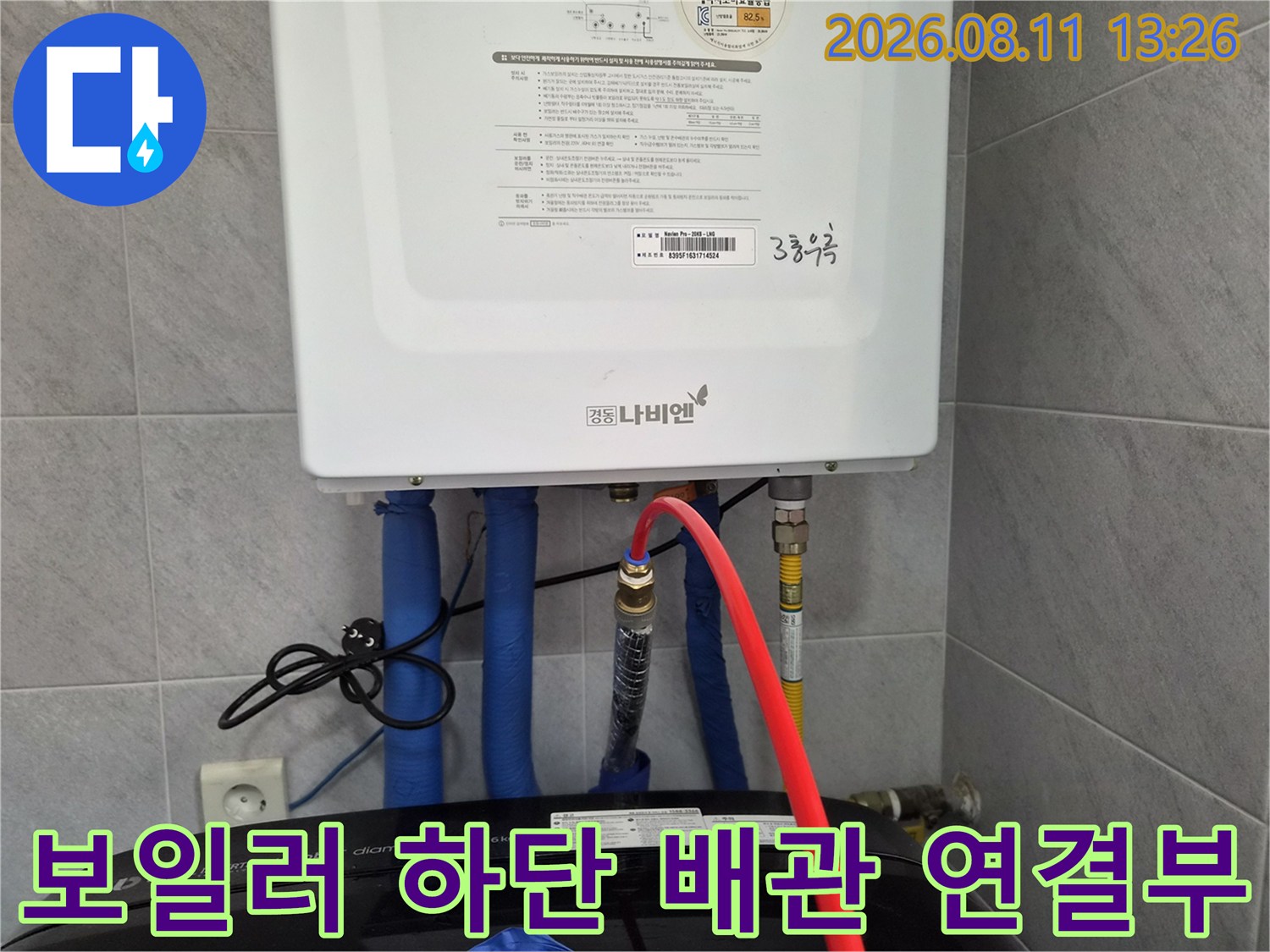 보일러 본체 아래로 연결된 다수의 배관과 호스들