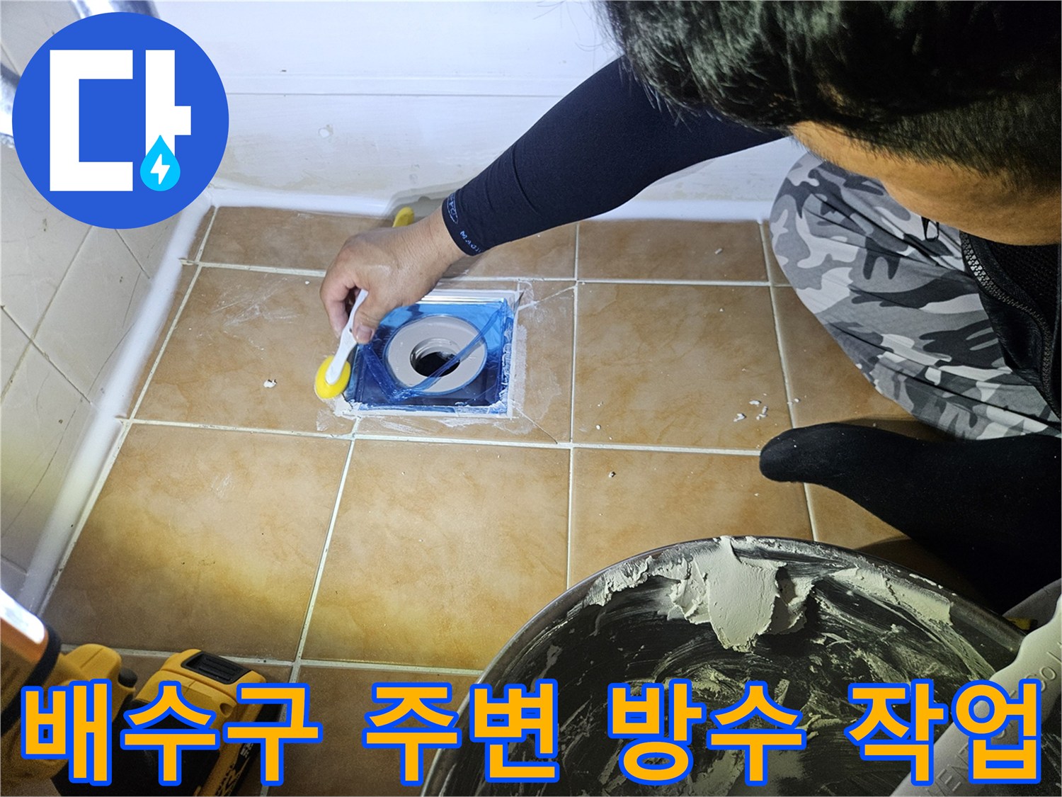 욕실 배수구 주변의 틈새를 메우는 방수 시공 모습
