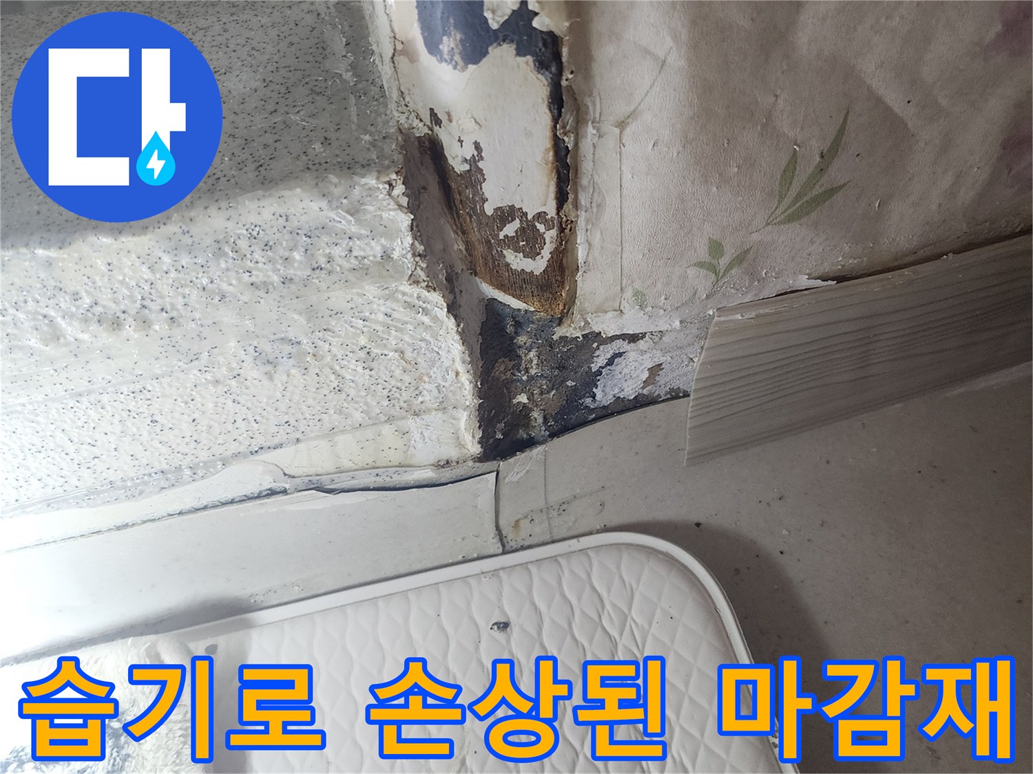 물기가 스며든 문틀 하단-벽지가 젖어 변형됨