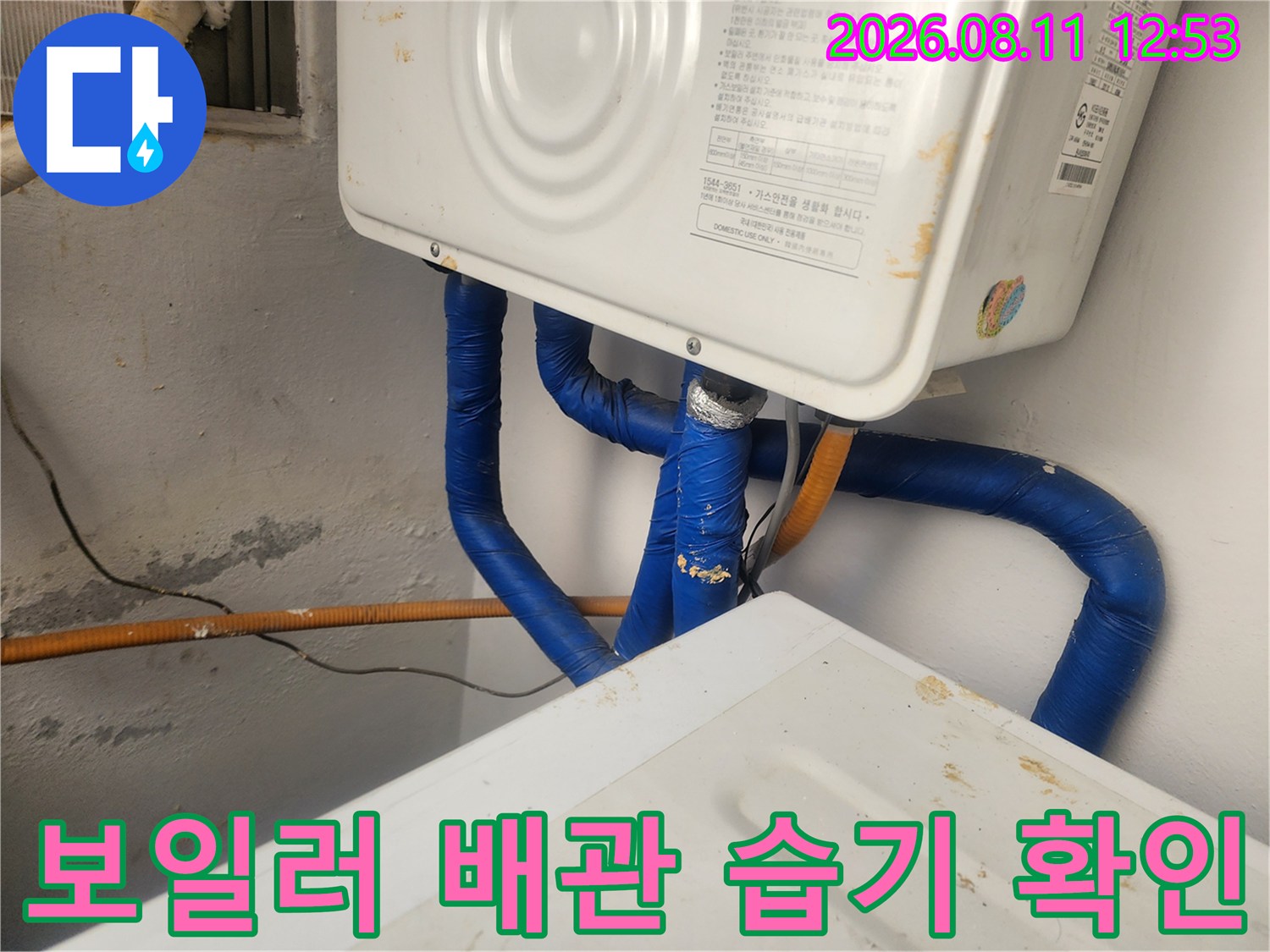 파란색 보온재가 감겨진-보일러 하단 배관 주변의 벽면 오염 상태