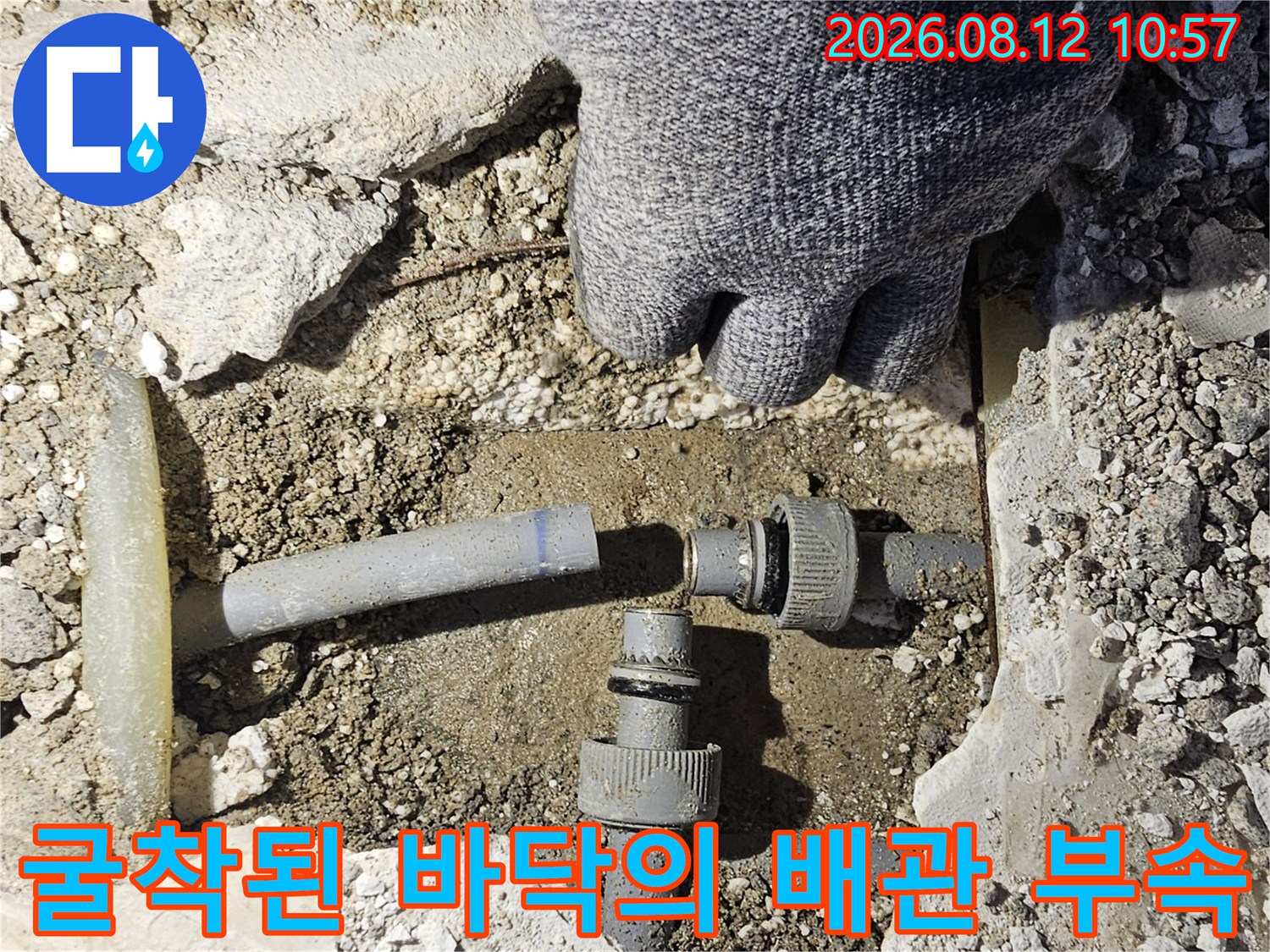누수 원인을 찾기 위해 굴착한 바격 내부의 노출된 수도 배관 부품